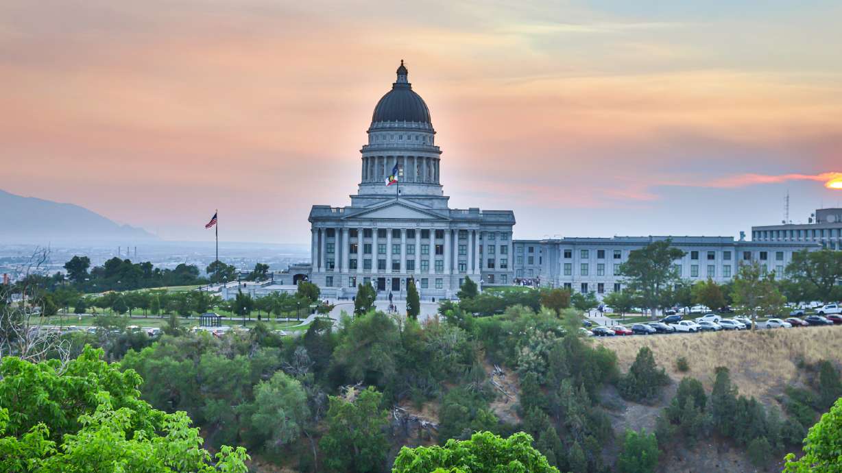 Smoke from Western wildfires settles over the Salt Lake Valley as the sun sets on Tuesday. The smoke is expected to remain in Utah over at least the next few days.