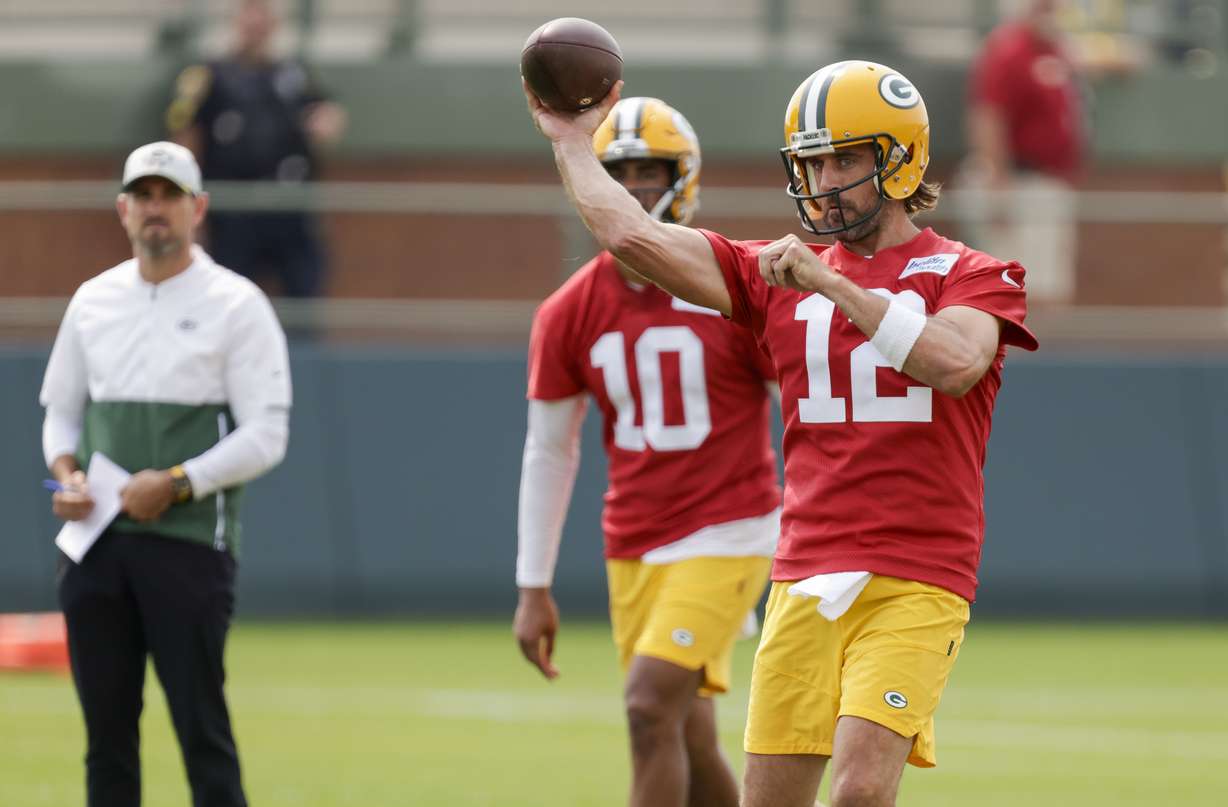 Green Bay Packers' quarterback Aaron Rodgers (12) passes while head coach Matt LaFleur and quarterback Jordan Love (10) watch during NFL football training camp Wednesday, July 28, 2021, in Green Bay, Wis.