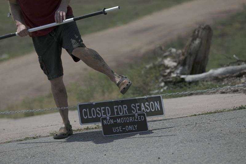 A kayaker walks over the chain at the Rock Cliff boat
ramp at Jordanelle Reservoir near Kamas on Wednesday, Aug. 4, 2021.
The Rock Cliff boat ramp remains out of the water but smaller,
nonmotorized vessels may be launched off the old road at the bottom
of the ramp.