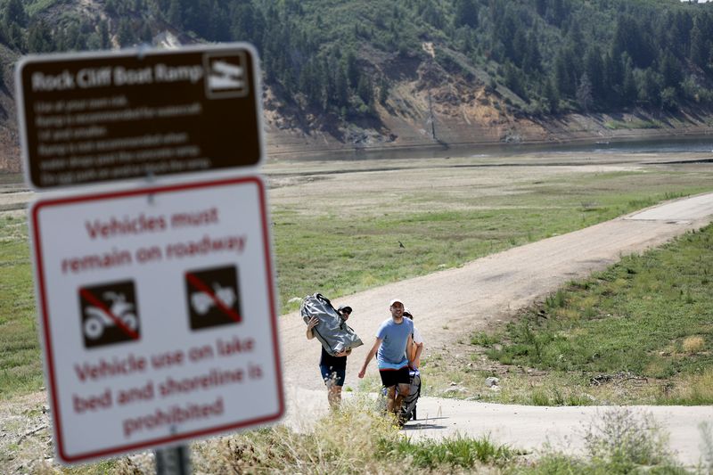 The Dobben family, who is visiting from Illinois, makes
the walk back to their car after kayaking at Jordanelle State Park
near Kamas on Wednesday, Aug. 4, 2021. The Rock Cliff boat ramp
remains out of the water but smaller vessels may be launched off
the old road at the bottom of the ramp.