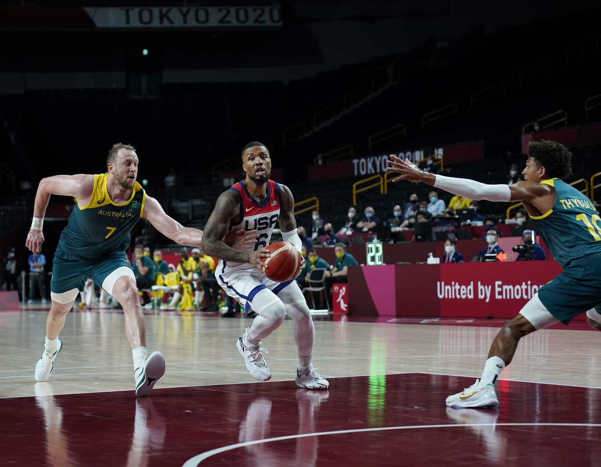 United States's Damian Lillard (6) drives between Australia's Joe Ingles (7), left, and Matisse Thybulle (10) during men's basketball semifinal game at the 2020 Summer Olympics, Thursday, Aug. 5, 2021, in Saitama, Japan.