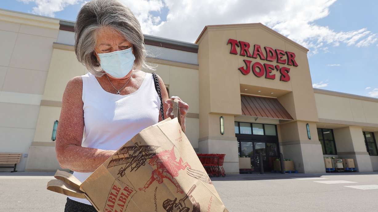 Susan Holding Rosetta leaves Trader Joe's in Cottonwood Heights after shopping on Friday, May 14. Trader Joe's is one of the first stores to drop the mask requirement for fully vaccinated customers.