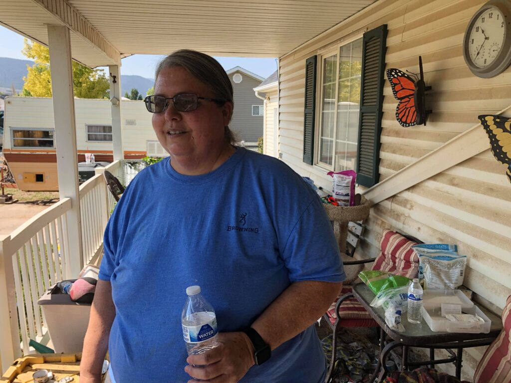 Michelle Pritchard stands on front porch outside her home in Enoch on Thursday. Flooding two days before a fire at her home turned out to be a blessing, she says.