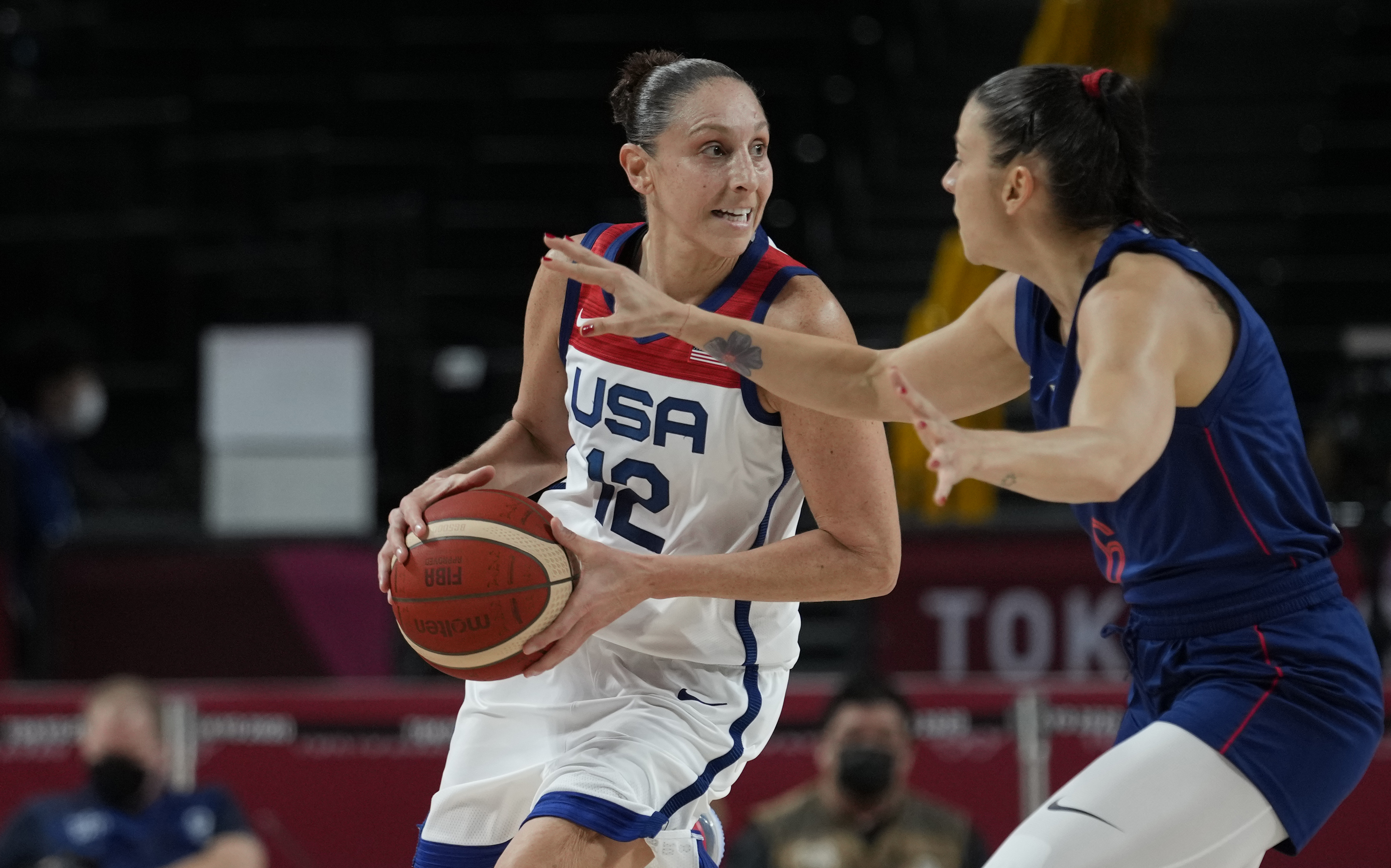 United States' Diana Taurasi (12) drives around Serbia's Sasa Cado (6) during women's basketball semifinal game at the 2020 Summer Olympics, Friday, Aug. 6, 2021, in Saitama, Japan.