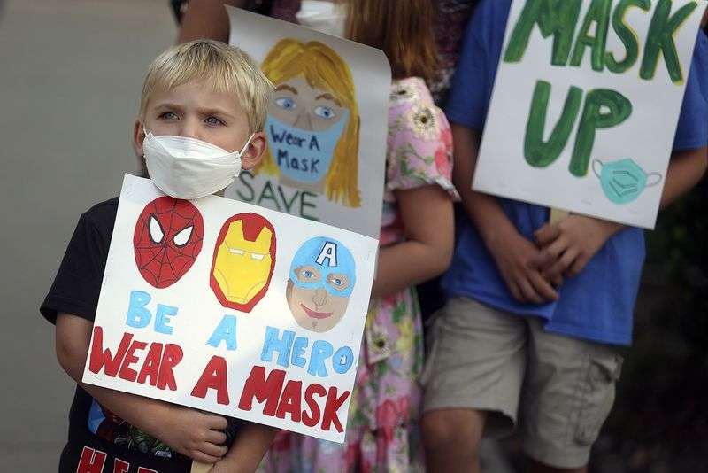 David Phillips holds a sign in support of school mask mandates outside of the Utah State Board of Education office in Salt Lake City on Friday.