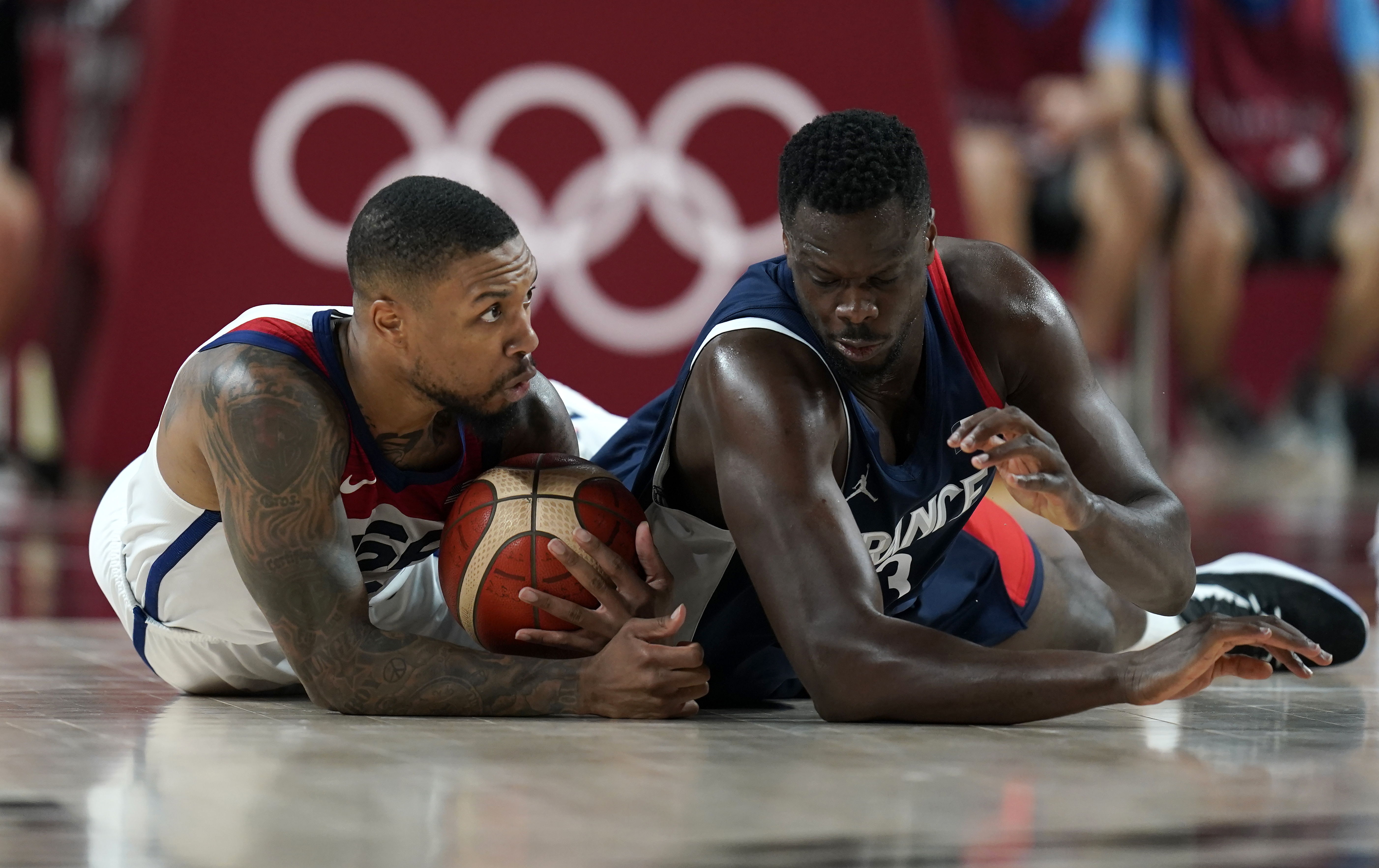 United States' Damian Lillard (6), left, and France's Moustapha Fall (93) fight for a loose ball during men's basketball gold medal game at the 2020 Summer Olympics, Saturday, Aug. 7, 2021, in Saitama, Japan.
