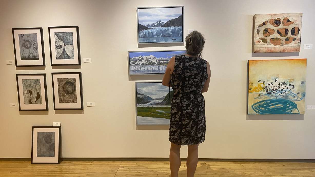 An attendee observes an exhibit at the Phillips Art Gallery on Thursday. The exhibit, titled "Our Global Climate Crisis," features 29 artists.
