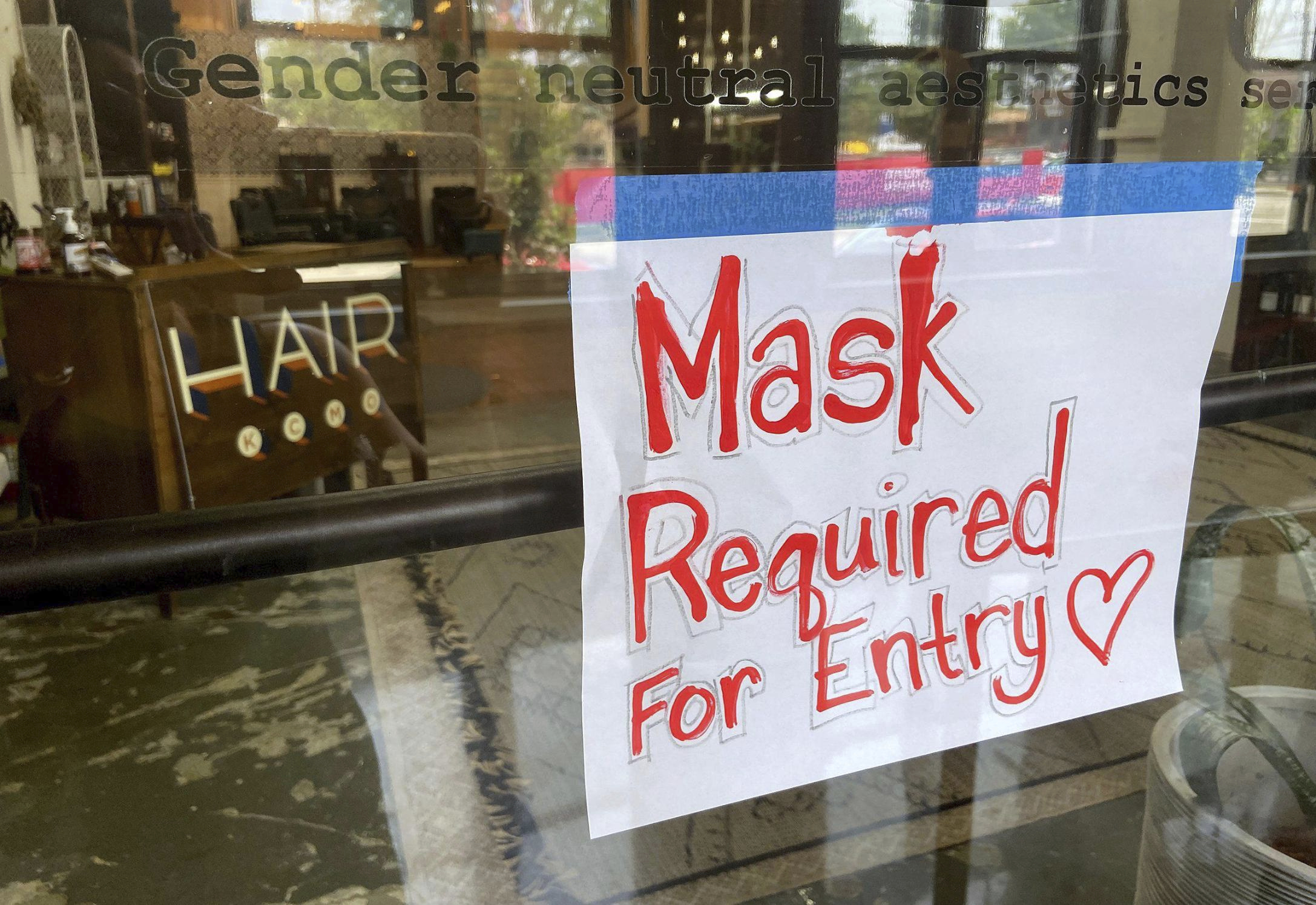 A sign on the door of a hair salon informing patrons that masks are required to be in the business in Kansas City, Mo., on July 28. Businesses large and small are reinstituting mask mandates and requiring vaccines of their customers as U.S. coronavirus cases rise.  
