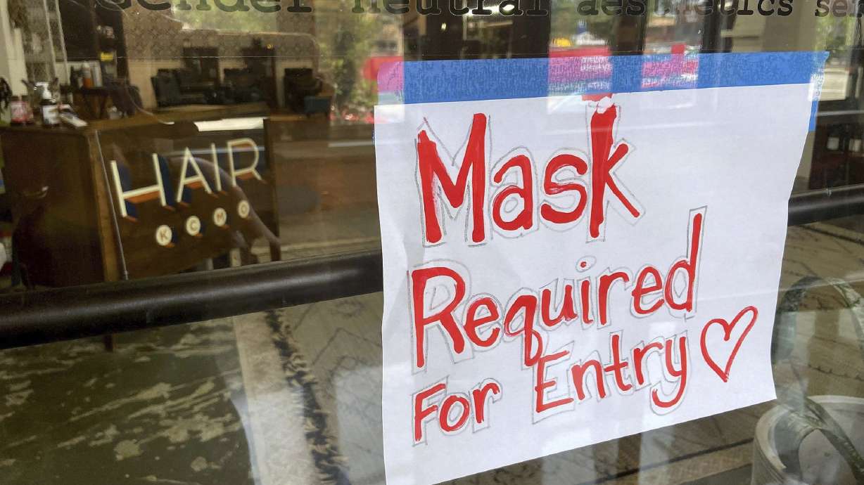 A sign on the door of a hair salon informing patrons that masks are required to be in the business in Kansas City, Mo., on July 28. Businesses large and small are reinstituting mask mandates and requiring vaccines of their customers as U.S. coronavirus cases rise.