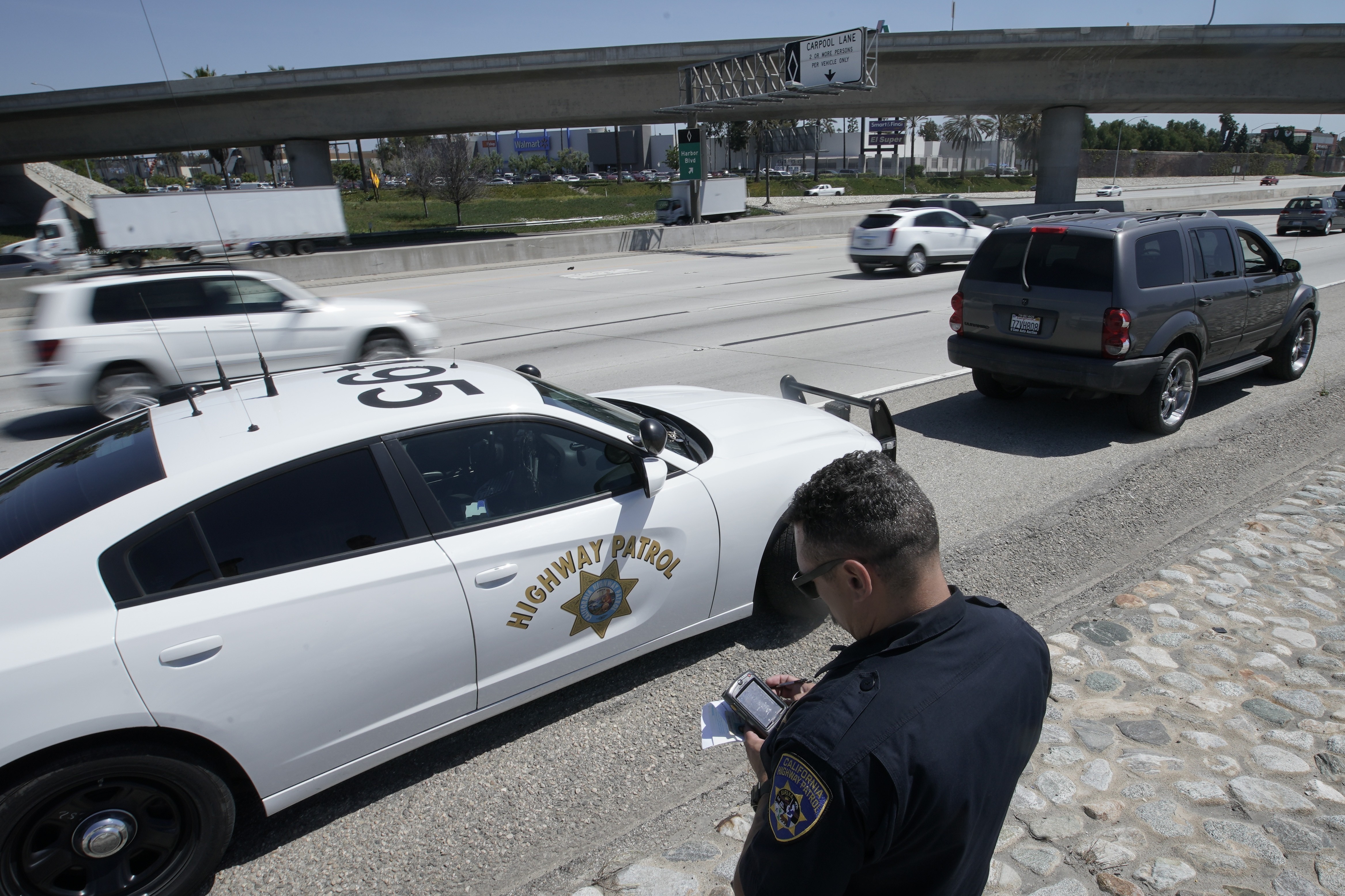 California Highway Patrol officer Troy Christensen stops a motorist along Interstate 5 who was suspected of speeding in Anaheim, Calif., on April 23. The number of highway deaths in 2020 was the greatest in more than a decade even though cars and trucks drove fewer miles during the pandemic.