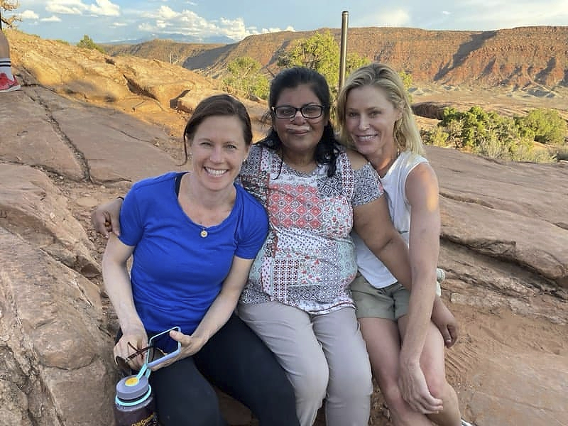 In this Tuesday, Aug. 3 photo provided by Shaji John, John's wife, Minnie John, center, poses with actress Julie Bowen, right, and Bowen's sister, Dr. Annie Luetkemeyer, left. The pair cared for her after she hit her head at Arches National Park.