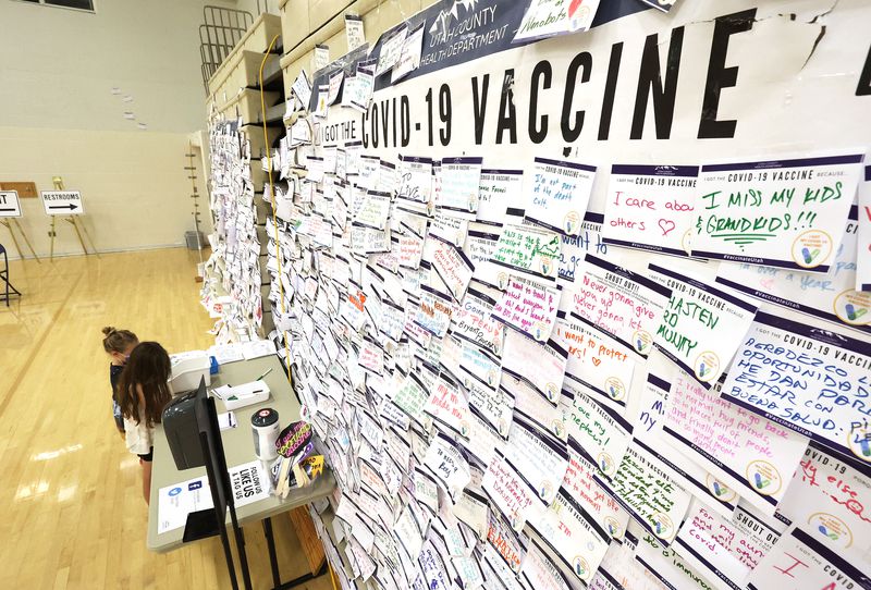 Hope and Lana Ruth Thompson color pictures for the
COVID-19 bulletin board in front of them while waiting for their
mother to get vaccinated at the former Provo High School in Provo
on Friday, Aug. 6, 2021.