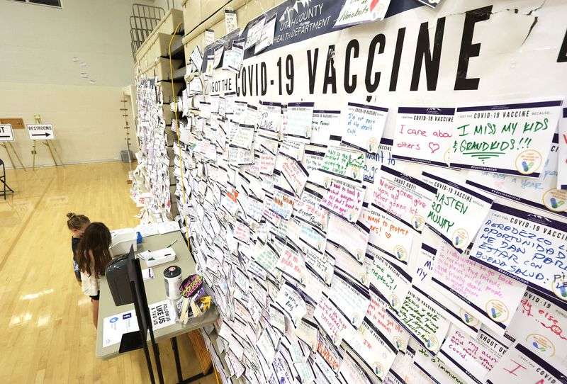 Hope and Lana Ruth Thompson color pictures for the
COVID-19 bulletin board in front of them while waiting for their
mother to get vaccinated at the former Provo High School in Provo
on Friday, Aug. 6, 2021.