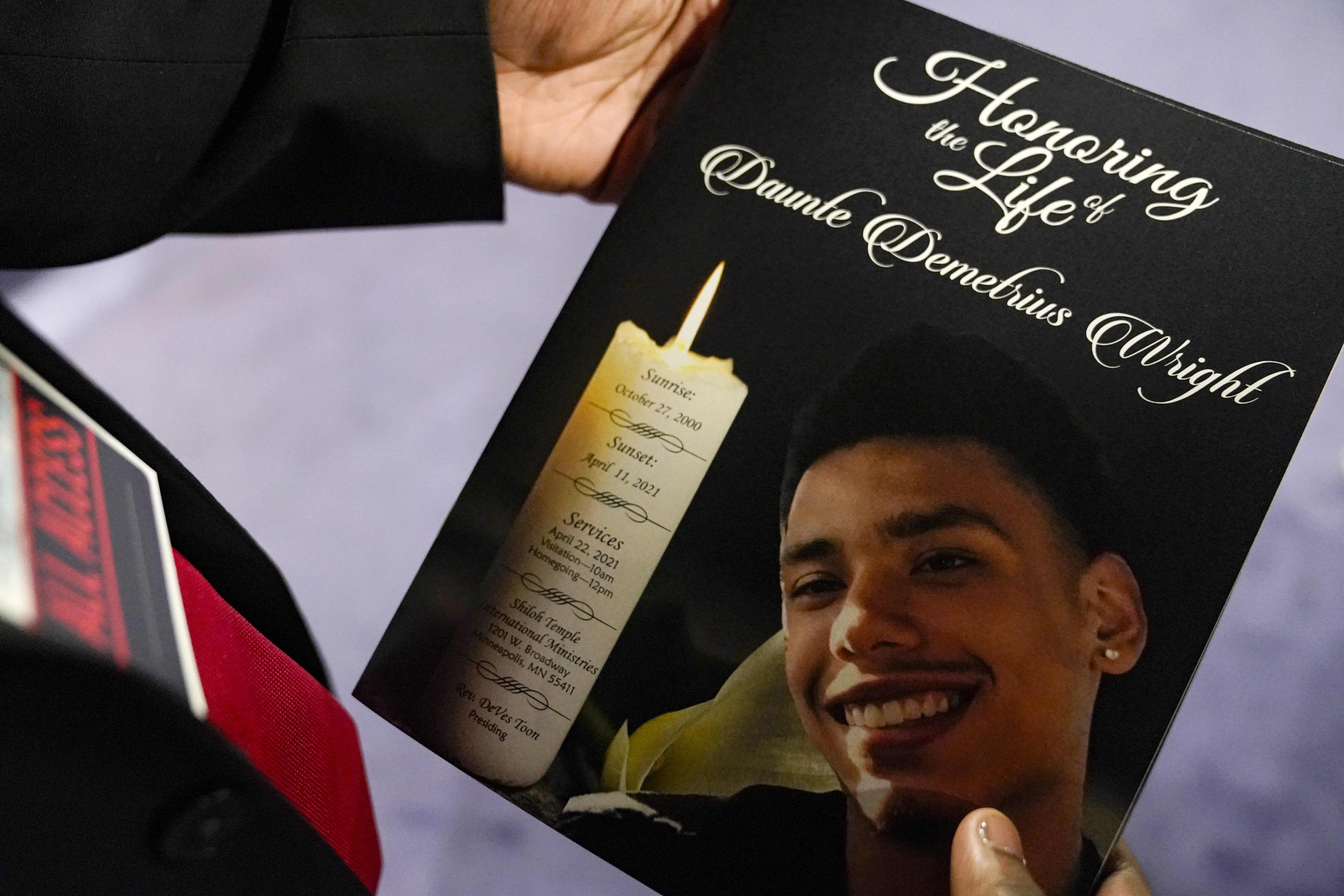 This April 22 photo shows a mourner holding the program for the funeral services of Daunte Wright at Shiloh Temple International Ministries in Minneapolis.