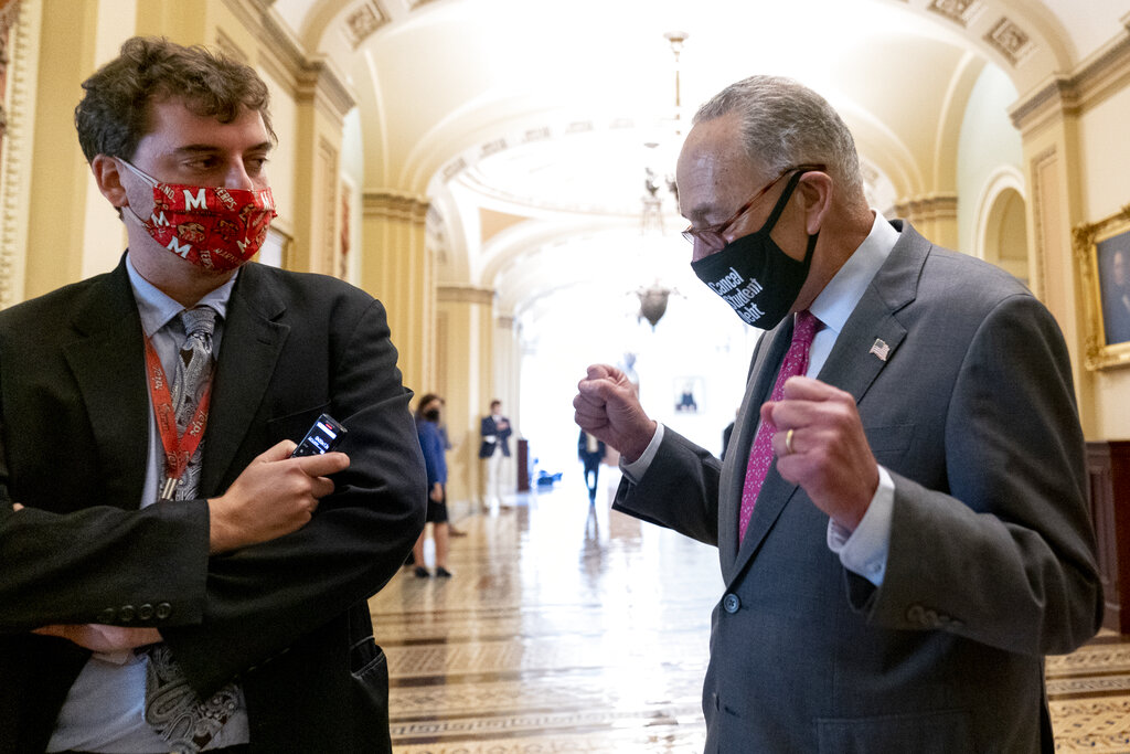 Politico co-congressional bureau chief Burgess Everett watches as Senate Majority Leader Chuck Schumer of N.Y. walks off the Senate floor and pumps his fists as the Senate approves a $1 trillion bipartisan infrastructure bill, sending a cornerstone of the Biden agenda to the House, on Capitol Hill in Washington, Tuesday. 