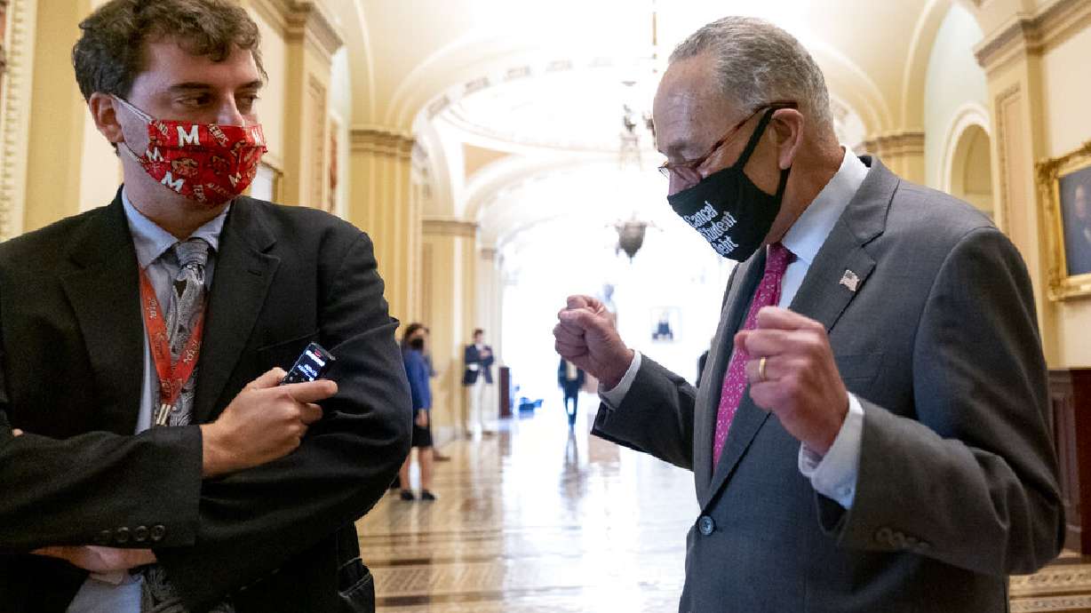 Politico co-congressional bureau chief Burgess Everett watches as Senate Majority Leader Chuck Schumer of N.Y. walks off the Senate floor and pumps his fists as the Senate approves a $1 trillion bipartisan infrastructure bill, sending a cornerstone of the Biden agenda to the House, on Capitol Hill in Washington, Tuesday.