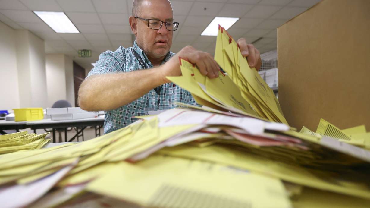 Salt Lake County elections coordinator Michael Fife gathers election envelopes to string and make sure no ballots are left inside in the Elections Management Center at the Salt Lake County Government Center in Salt Lake City on Tuesday.