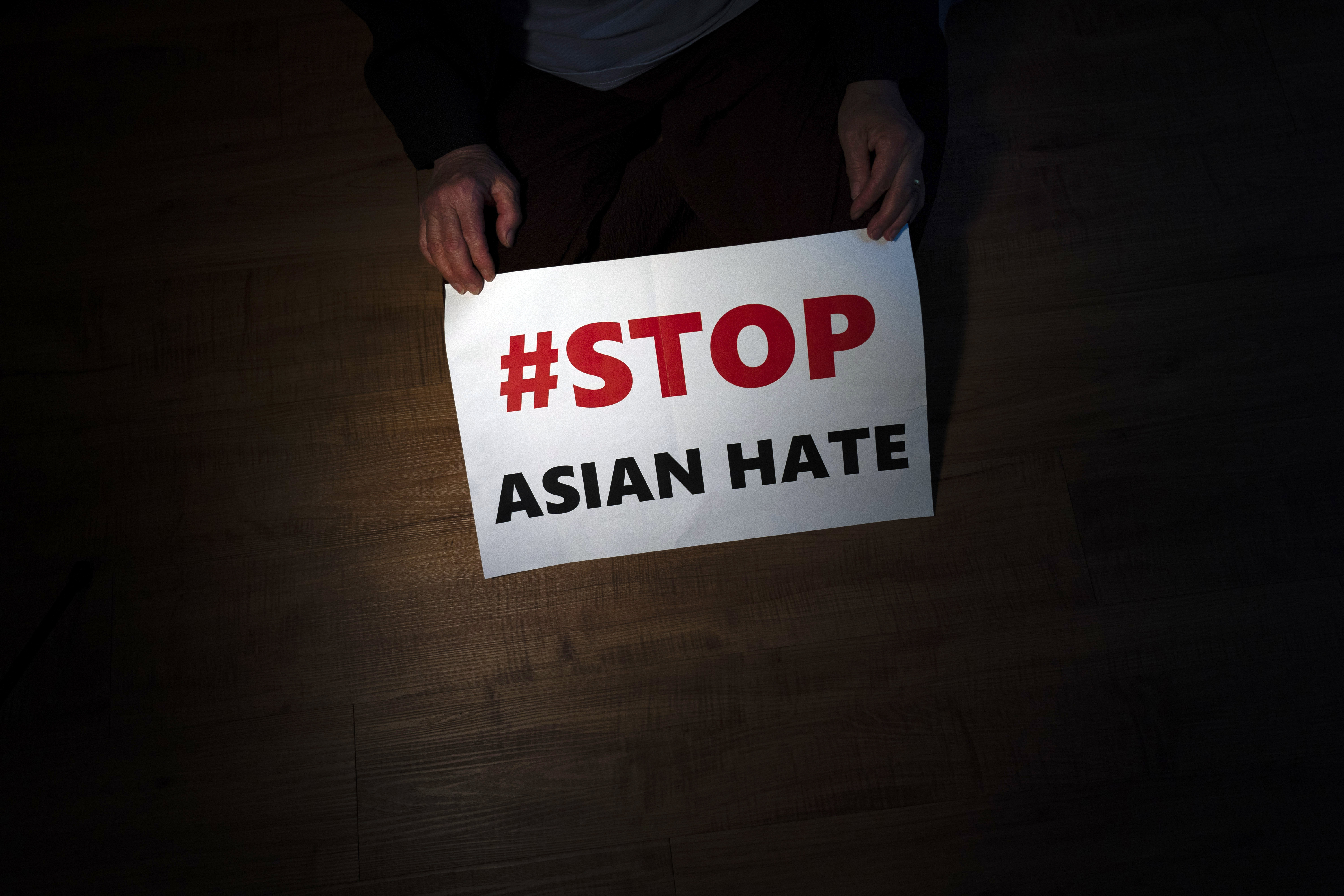 Jen Ho Lee, a 76-year-old South Korean immigrant, poses in her apartment in Los Angeles with a sign from a recent rally against anti-Asian hate crimes she attended on March 31, 2021. A new report released Thursday has found the frequency of anti-Asian incidents reported in the U.S. so far this year seems poised to surpass last year despite months of political and social activism. 