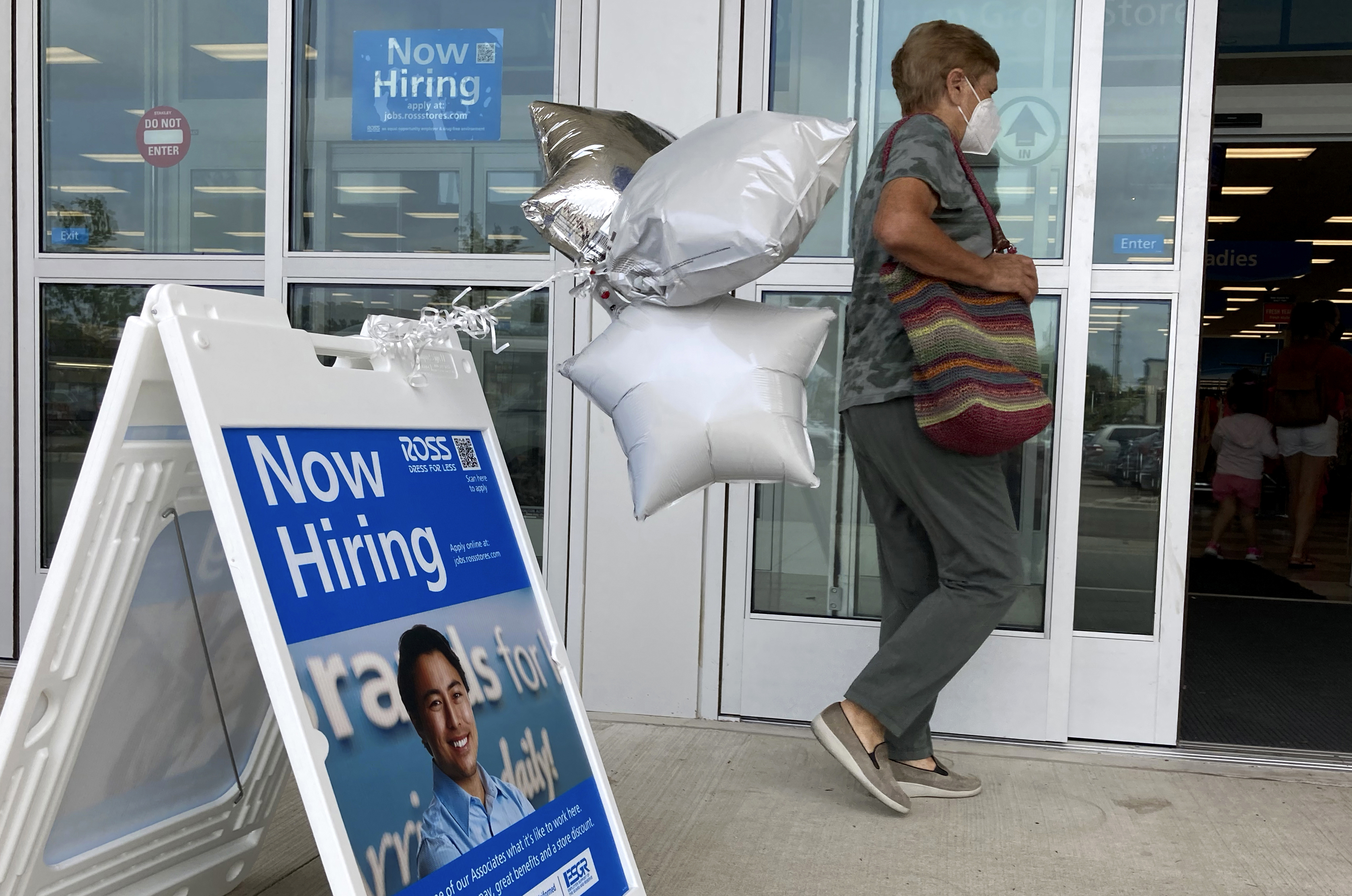 A shopper passes a hiring sign while entering a retail store in Morton Grove, Ill., Wednesday, July 21, 2021. The number of Americans seeking unemployment benefits fell for a third straight time last week.