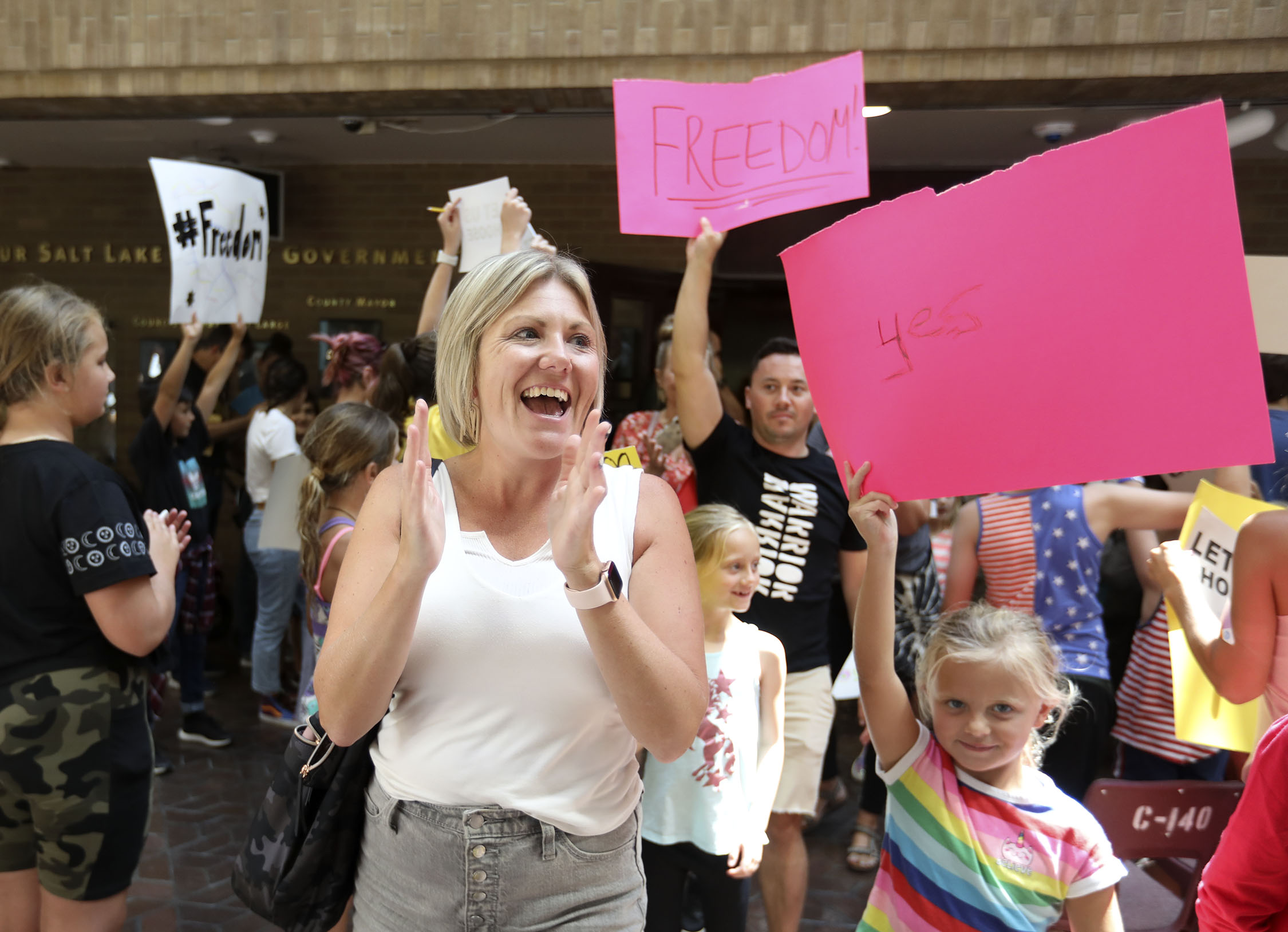 People celebrate the Salt Lake County Council's decision to overturn the health department's "order of restraint" that would have required K-6 students to wear masks when school starts during a meeting at the Salt Lake County Government Center in Salt Lake City on Thursday, Aug. 12, 2021. The proposal to overturn the order passed 6-3 along party lines, with Republicans voting to overturn the order.