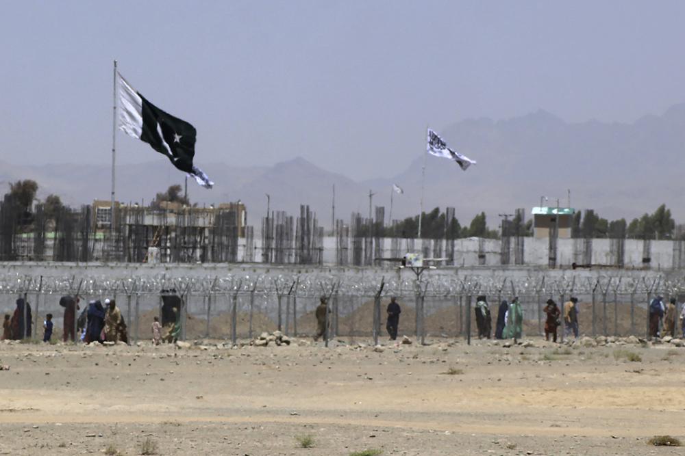 Stranded people cross the border between Pakistan and Afghanistan, in Chaman, Pakistan, Friday. Pakistan opened its Chaman border crossing for people who had been stranded in recent weeks. Juma Khan, the Pakistan border town's deputy commissioner, said the crossing was reopened following talks with the Taliban.