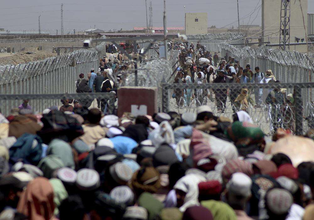 Stranded people crossing the border between Pakistan Afghanistan, in Chaman, Pakistan, Friday. Pakistan opened its Chaman border crossing for people who had been stranded in recent weeks. Juma Khan, the Pakistan border town's deputy commissioner, said the crossing was reopened following talks with the Taliban.