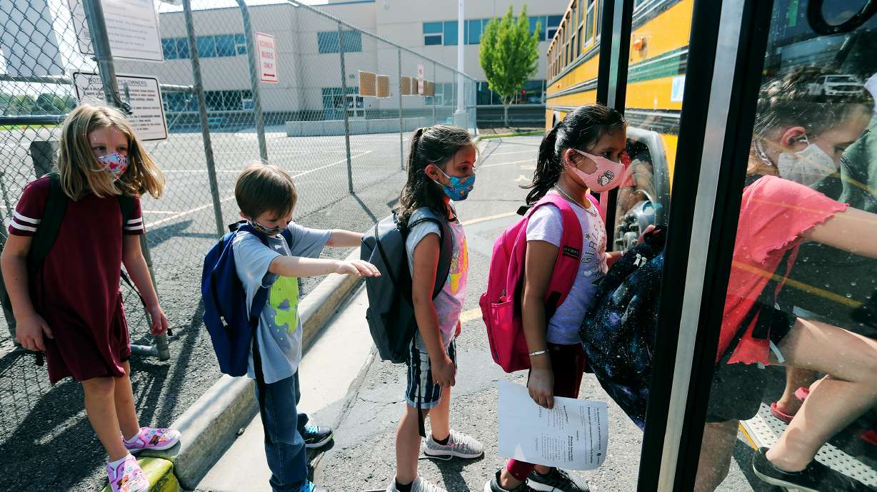 Students at Woodrow Wilson Elementary School in South Salt Lake wear masks as the get on a bus to go home on Aug. 24, 2020. Masks may still be required on school buses this school year due to federal mandates, despite no district mask mandates.