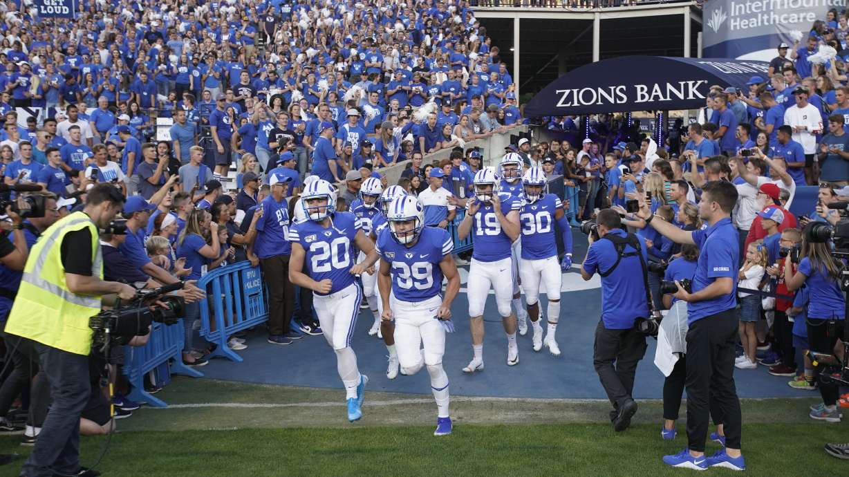 BYU football players enter the field to warm up for an NCAA college football game against Utah in Provo, Utah, in this Thursday, Aug. 29, 2019, file photo.