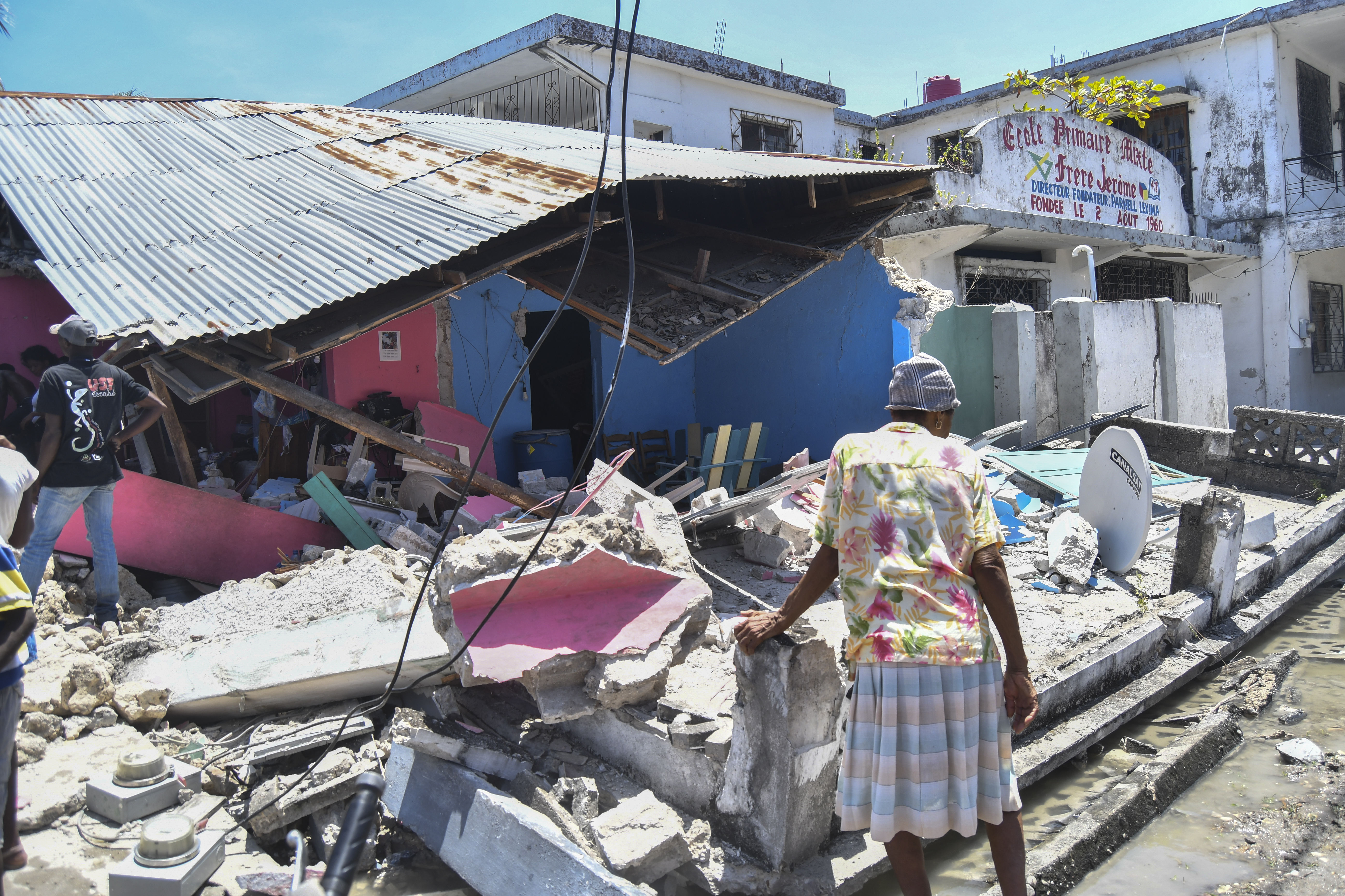 A woman stands in front of a destroyed home in the aftermath of an earthquake in Les Cayes, Haiti, Saturday, Aug. 14, 2021. A 7.2 magnitude earthquake struck Haiti on Saturday, with the epicenter about 125 kilometers ( 78 miles) west of the capital of Port-au-Prince, the US Geological Survey said.