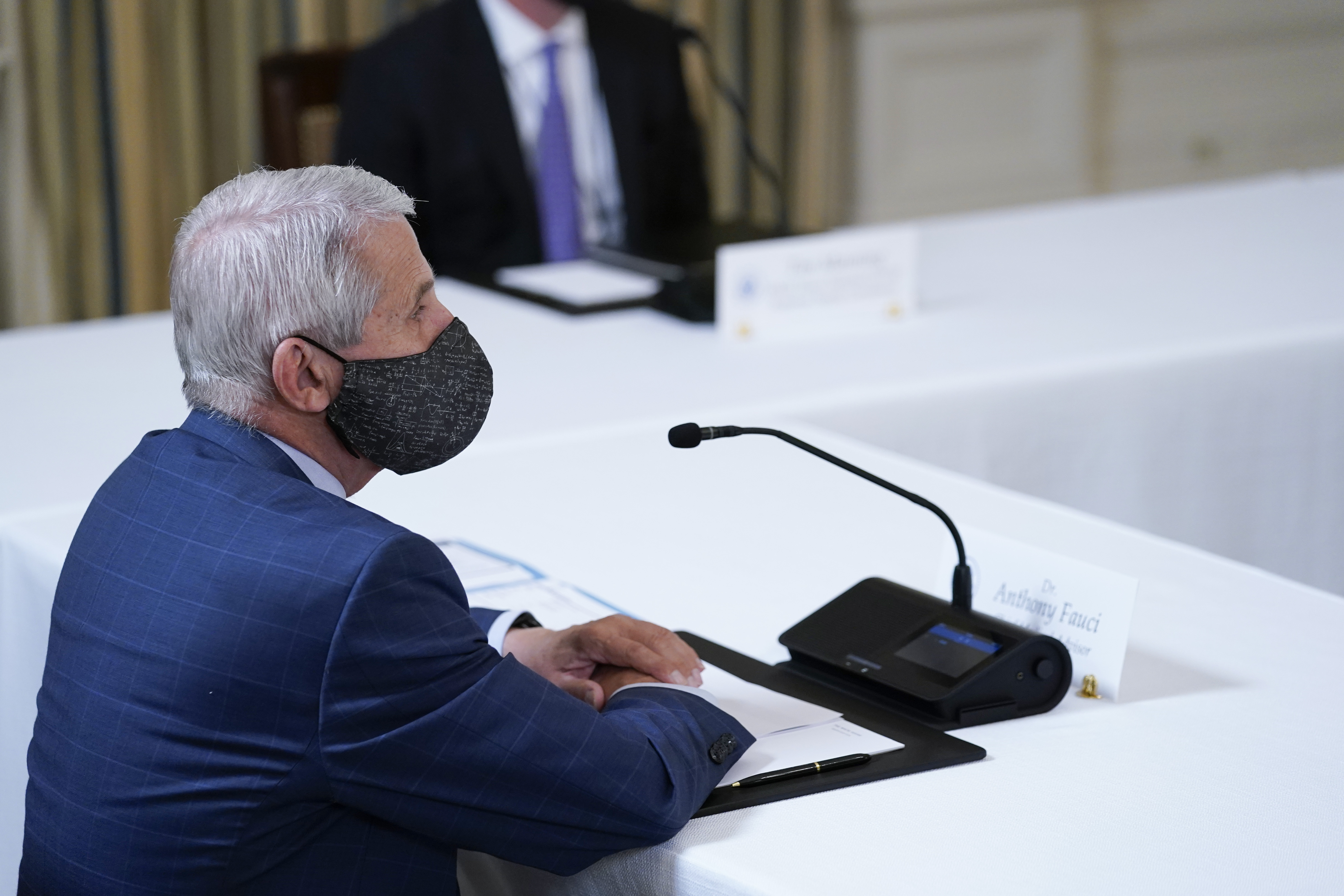 Dr. Anthony Fauci, director of the National Institute of Allergy and Infectious Diseases, listens as U.S. President Joe Biden receives a briefing in the State Dining Room at the White House in Washington, Tuesday, on how the COVID-19 pandemic is impacting hurricane preparedness.