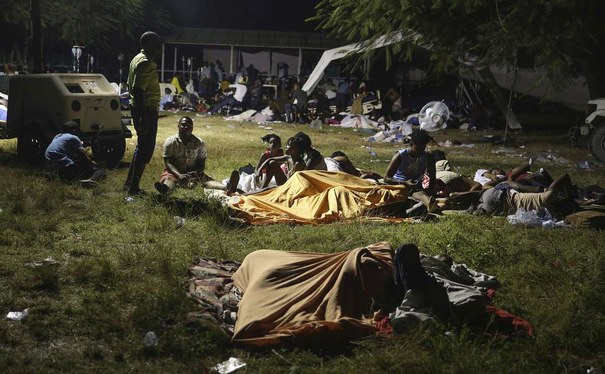 People displaced from their earthquake destroyed homes spend the night outdoors in a grassy area that is part of a hospital in Les Cayes, Haiti, late Saturday. A powerful magnitude 7.2 earthquake struck southwestern Haiti on Saturday.