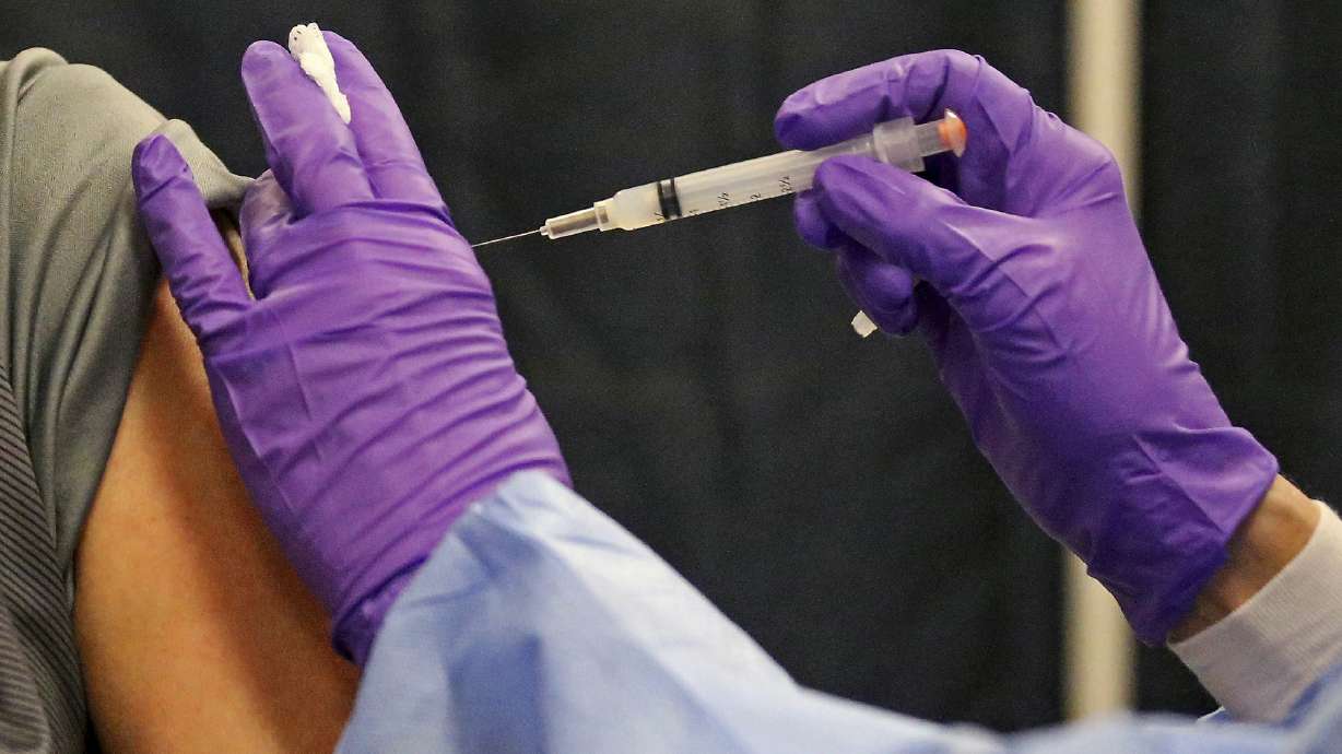 A man gets a COVID-19 vaccine at a mass vaccination site at the Natick Mall on Wednesday, Feb. 24, 2021, in Natick, Mass. U.S. experts are expected to recommend COVID-19 vaccine boosters for all Americans, regardless of age, eight months after they received their second dose of the shot, to ensure lasting protection against the coronavirus as the delta variant spreads across the country.
