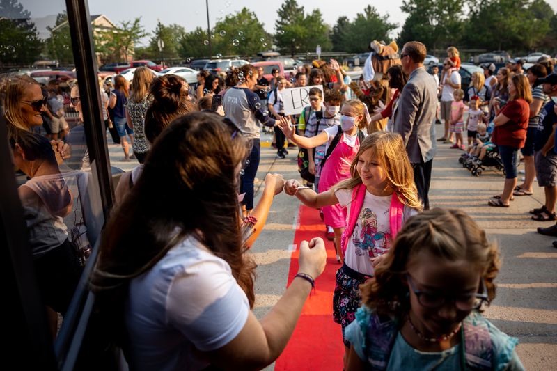 Dasha Zolotuhina, 10, who is entering fifth grade,
fist-bumps a teacher as she and other students are given the red
carpet treatment as they arrive for the first day of school at
Altara Elementary in Sandy on Monday.