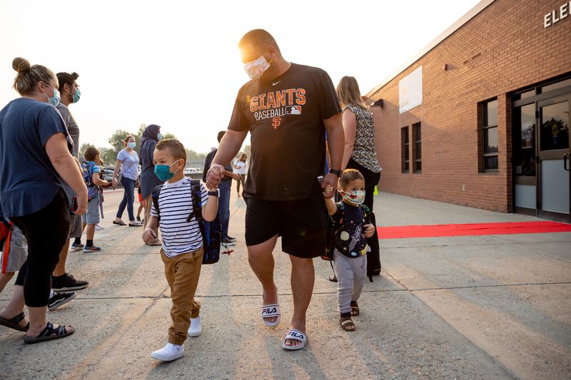 Leonardo da Silva walks with his sons, Leonardo Jr., 6,
left, and Oscar, 2, before the first day of school at Altara
Elementary in Sandy on Monday.