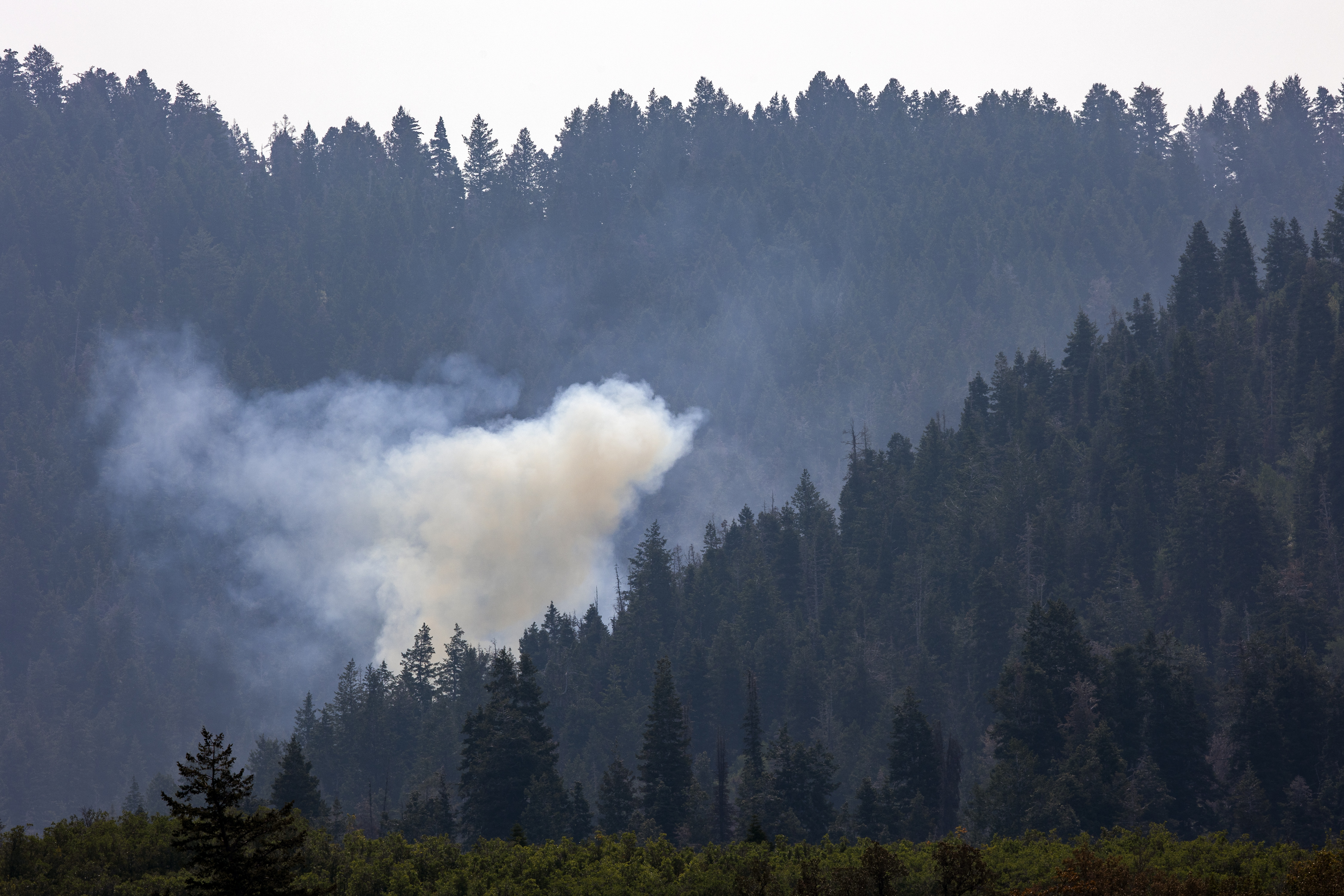 A hot spot flares up as crews fight the Parleys Canyon Fire near Park City on Monday. Firefighters said Tuesday they fear an incoming storm could cause the blaze to spread. 