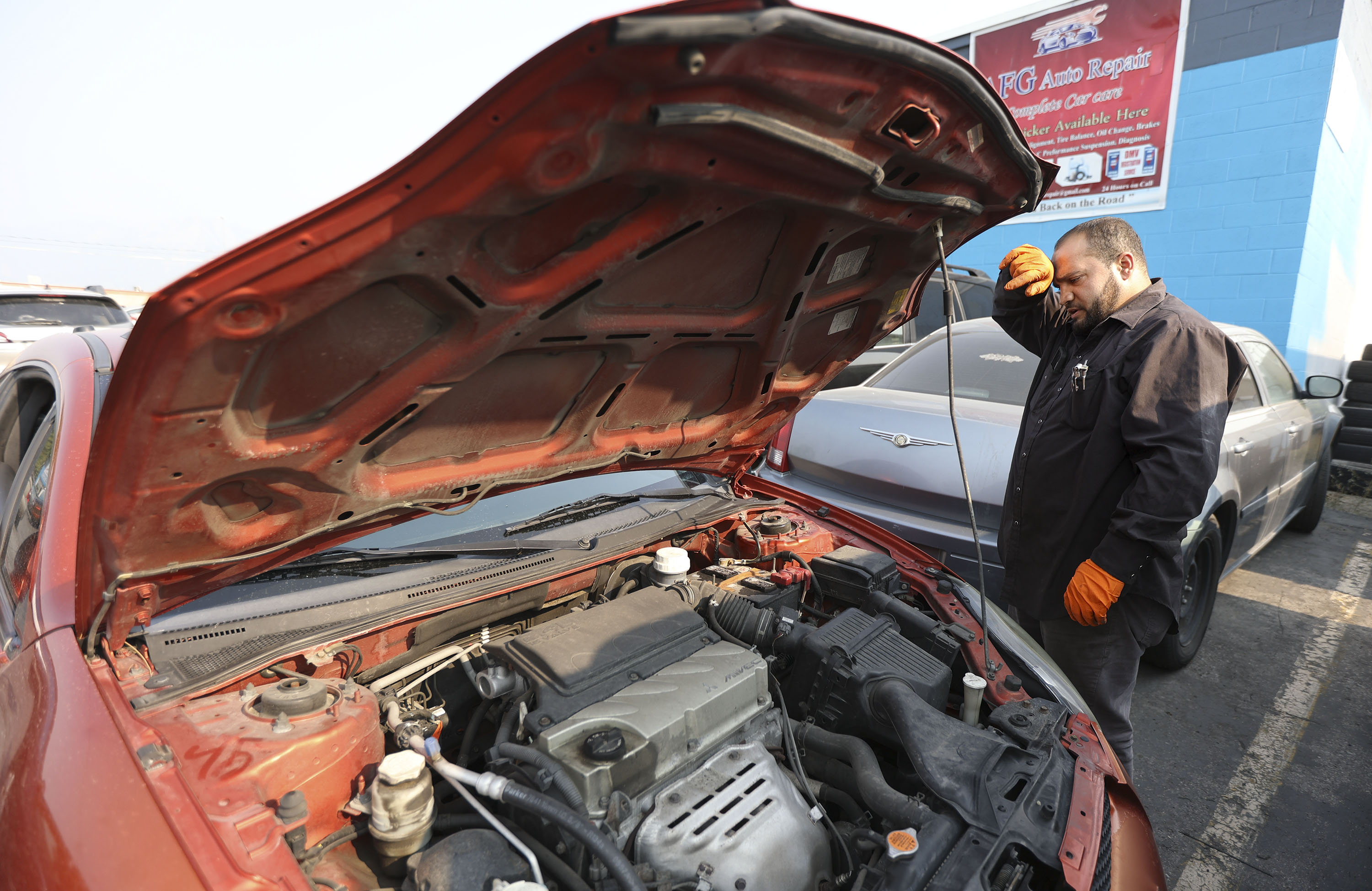 Samiullah Sharifi, who used to be an interpreter for the U.S. Army in Afghanistan, works at his shop, AFG Auto, in Murray on Monday.