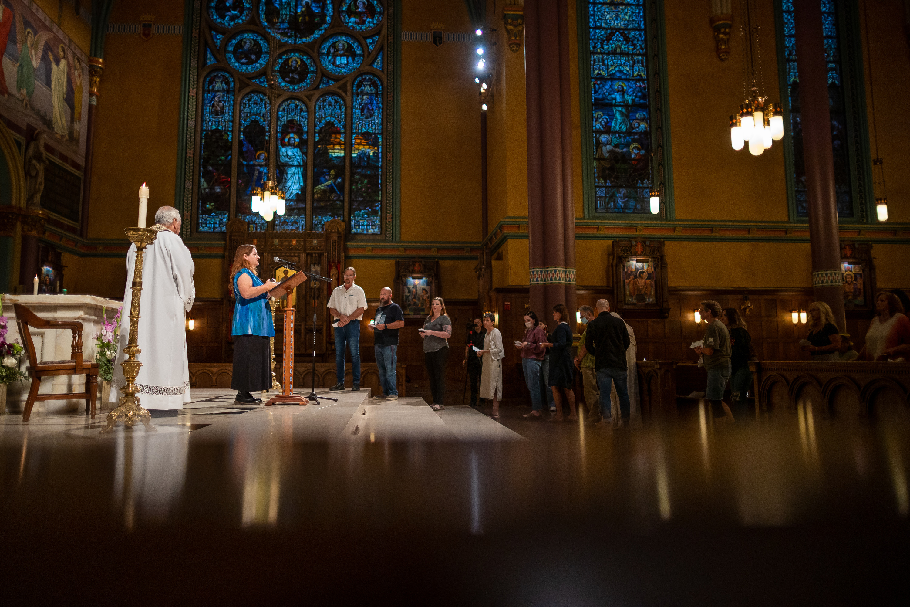 The Very Rev. Martin Diaz listens as Wendy Garvin, executive director of Unsheltered Utah, reads the name of someone who died and whose remains were never claimed during a service at The Cathedral of the Madeleine in Salt Lake City on Tuesday.
