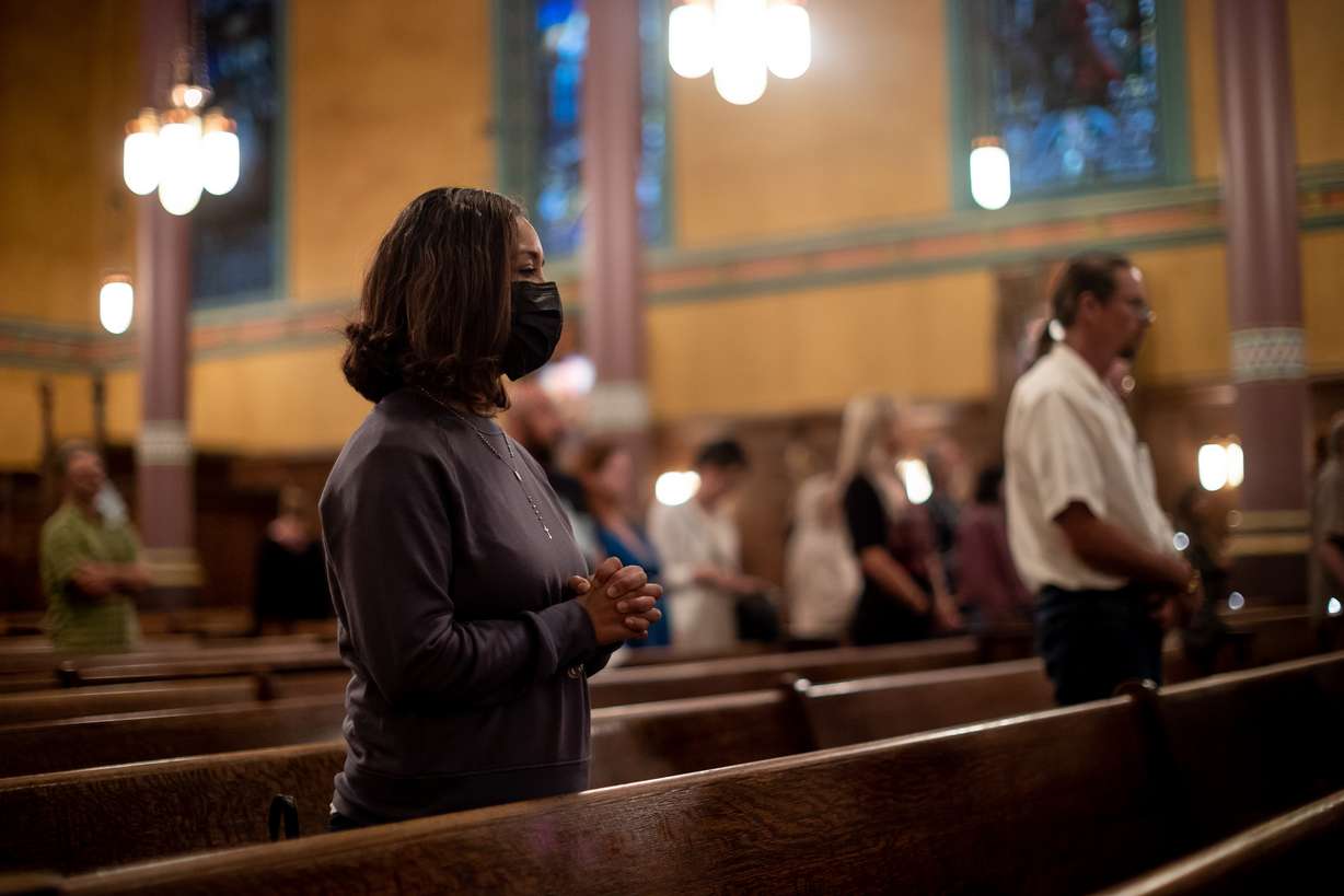 Nellie Estrada prays with others during a service at the Cathedral of the Madeleine honoring more than 150 people who died and whose remains were never claimed in Salt Lake City on Tuesday.