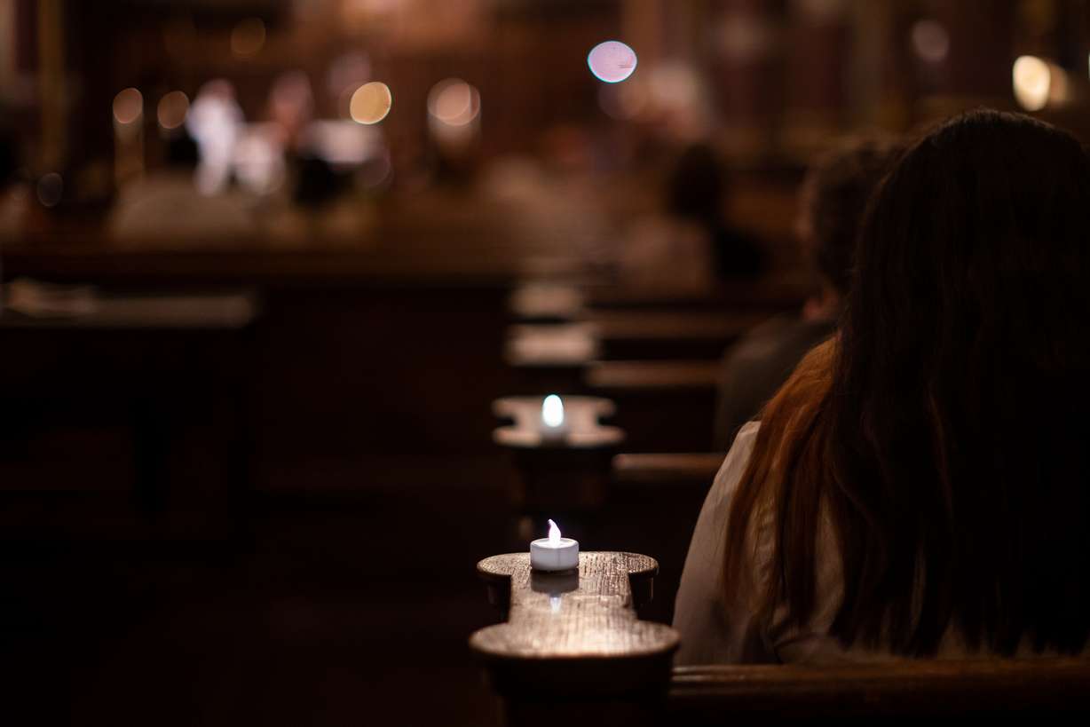 Artificial candles flicker beside attendees at a service honoring more than 150 people who died and whose remains were never claimed at the Cathedral of the Madeleine in Salt Lake City on Tuesday.