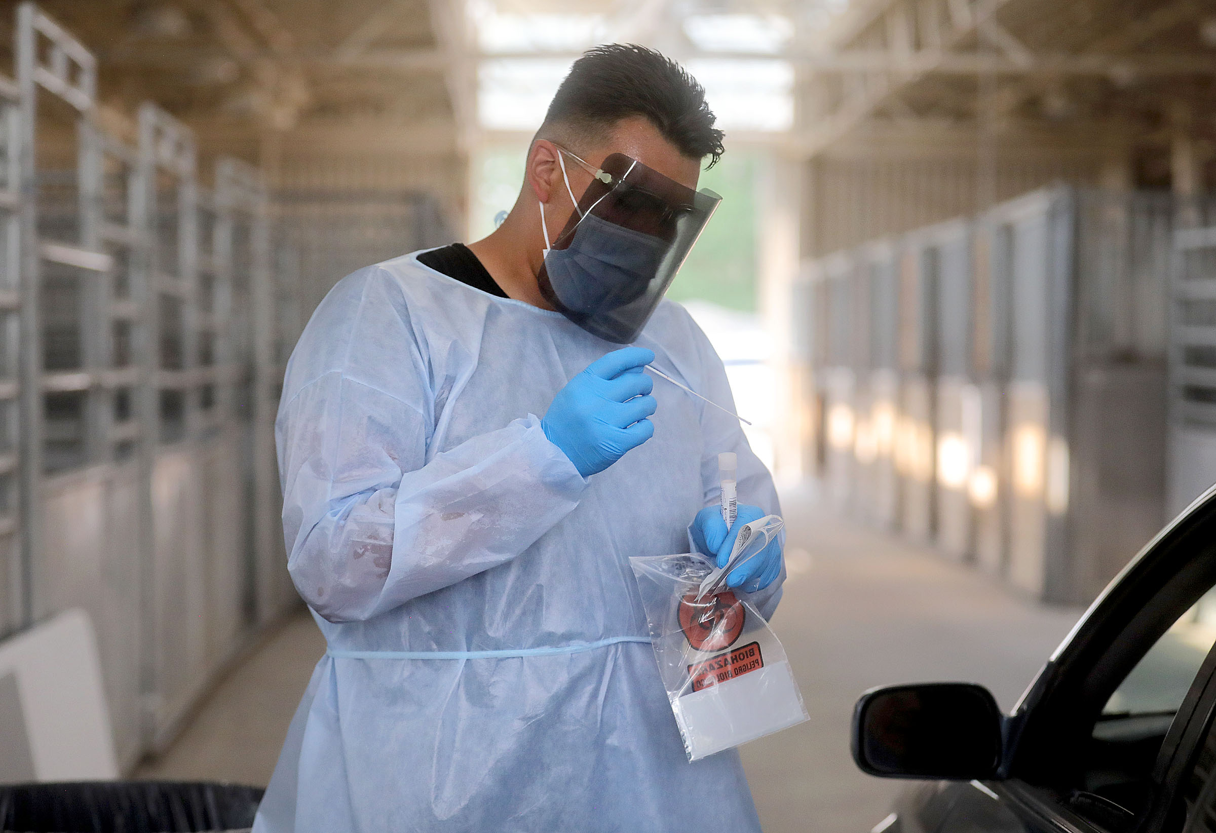 Xander Yazzie, a Utah National Guard service member, performs a COVID-10 test at the Utah State Fairpark in Salt Lake City on Monday. Utah health officials reported 1,488 new COVID-19 cases and 12 additional deaths on Wednesday.
