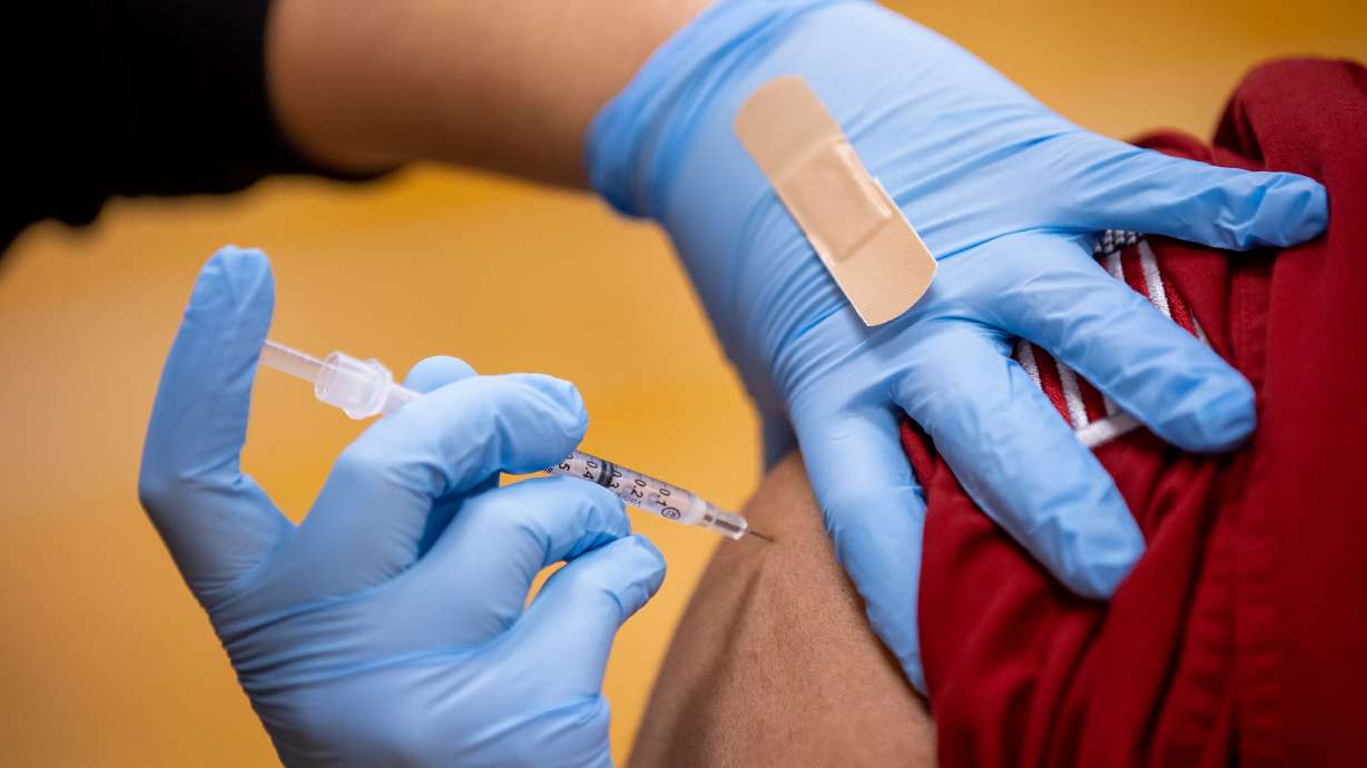 Smith's pharmacy technician Wendy Flores administers a COVID-19 vaccine during an event at a church in Salt Lake City on March 20. As some hospitals and other employers are requiring their employees to receive the COVID-19 vaccination, some conservative religious groups have pushed back, often claiming a religious exemption to the vaccine.