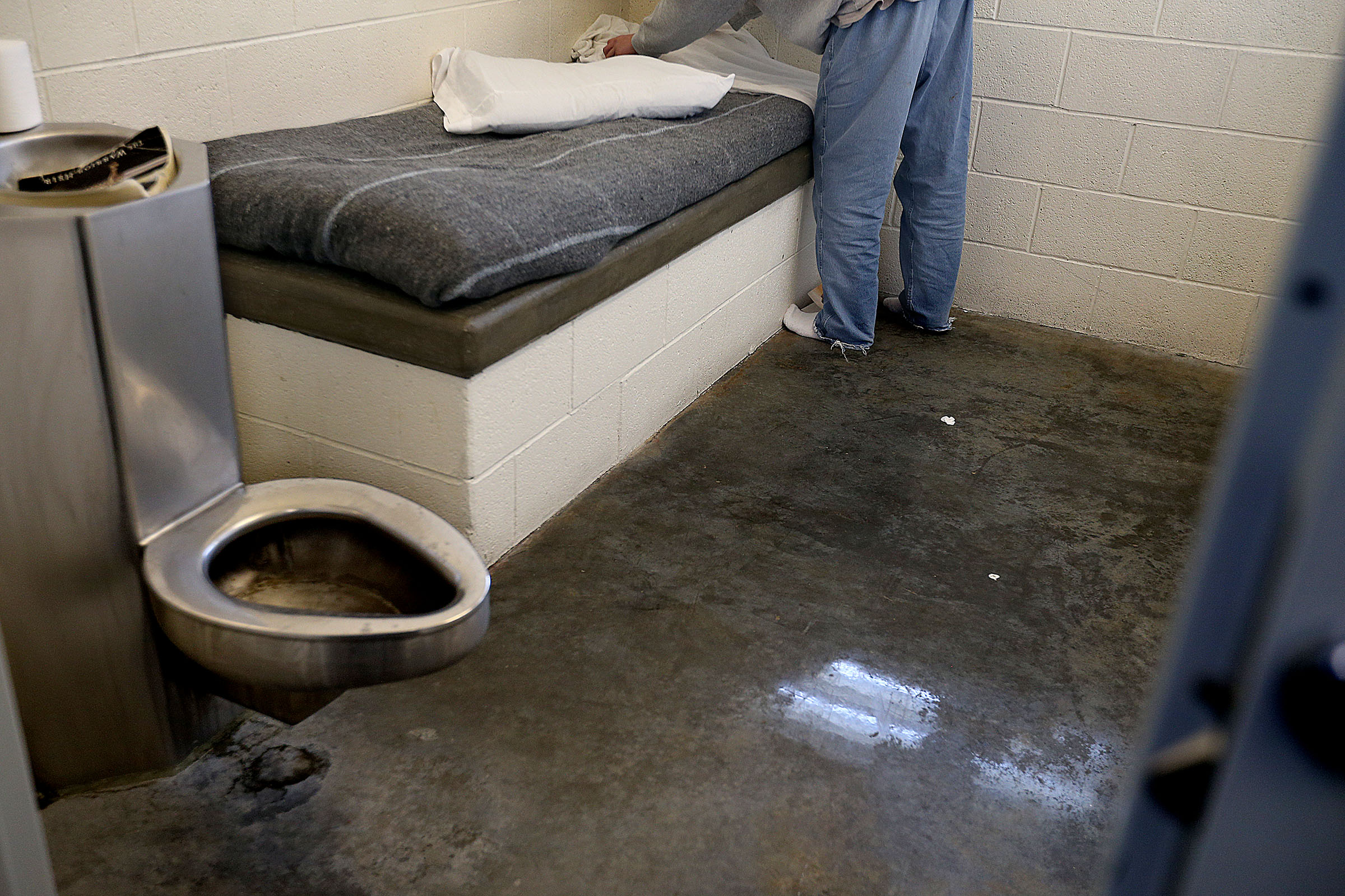 A youth makes his bed in his room at the Salt Lake Valley Youth Center in this Feb. 5, 2016 photo. Two employees at the center were charged Wednesday with crimes connected to a case involving the broken arm of a teenage resident.
