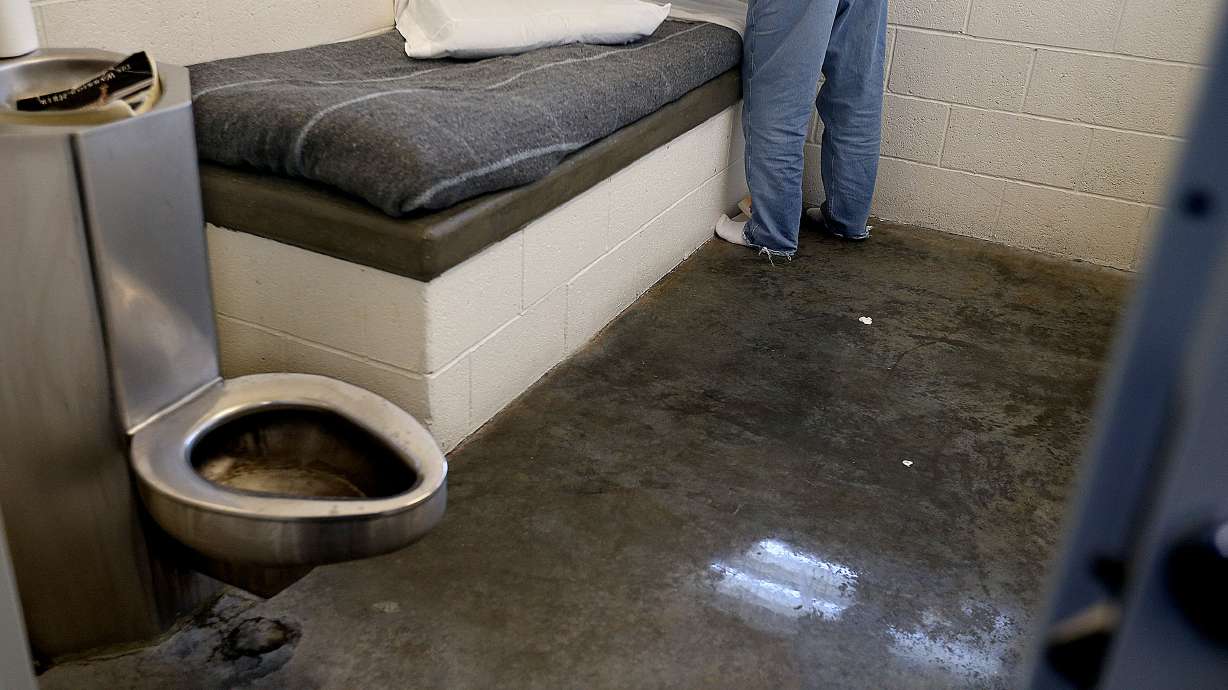 A youth makes his bed in his room at the Salt Lake Valley Youth Center in this Feb. 5, 2016 photo. Two employees at the center were charged Wednesday with crimes connected to a case involving the broken arm of a teenage resident.