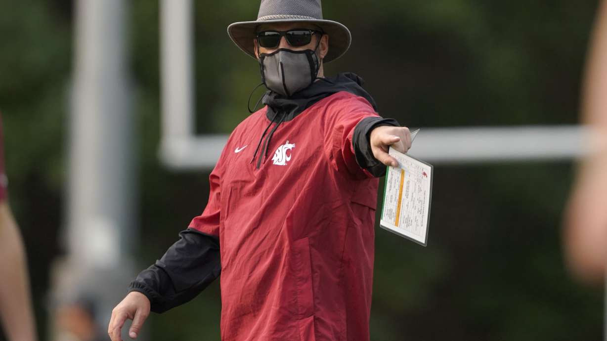 Washington State head coach Nick Rolovich wears a mask as he gives directions during the first day of NCAA college football practice, Friday, Aug. 6, 2021, in Pullman, Wash.