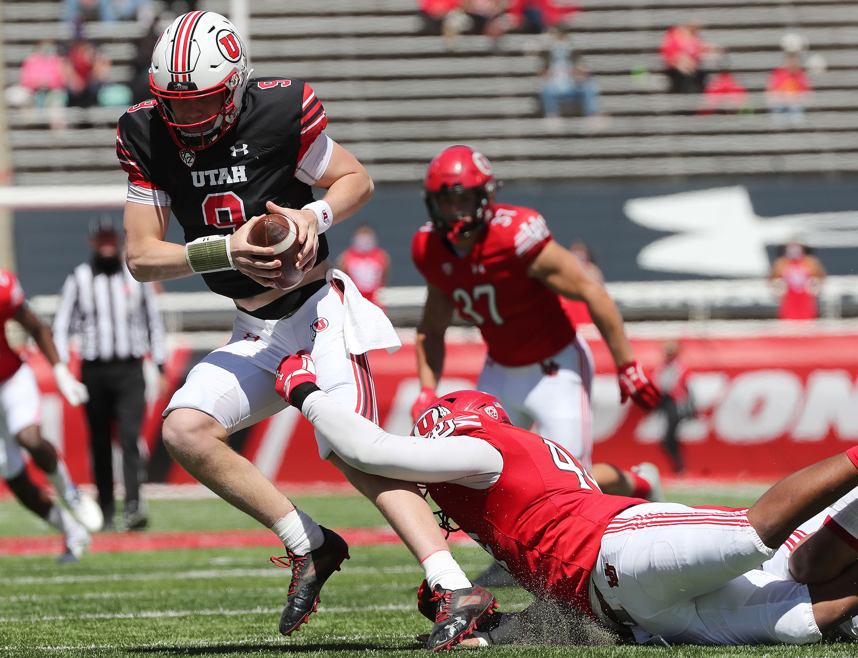 Utah Utes quarterback Cooper Justice is sacked by Utah Utes defensive end Xavier Carlton (44) during the Red and White game in Salt Lake City on Saturday, April 17, 2021.