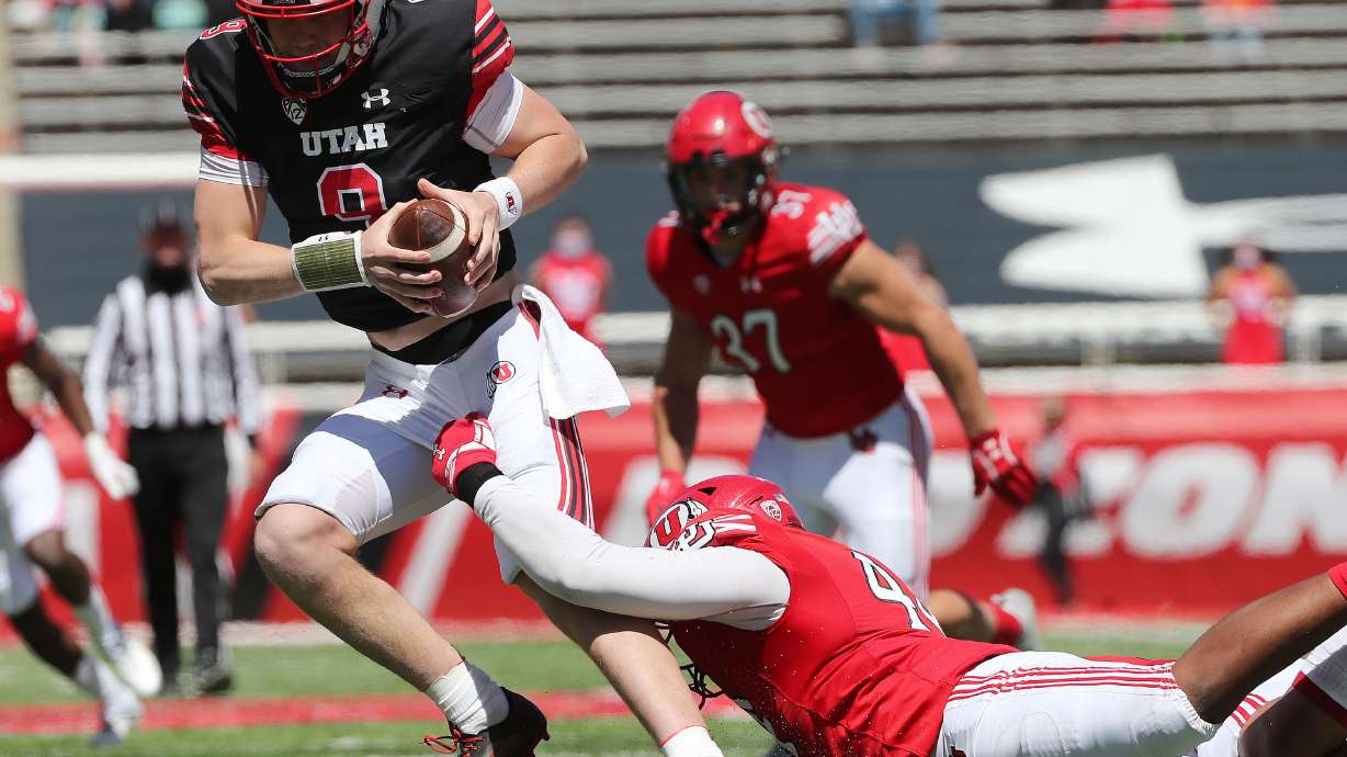 Utah Utes quarterback Cooper Justice is sacked by Utah Utes defensive end Xavier Carlton (44) during the Red and White game in Salt Lake City on Saturday, April 17, 2021.