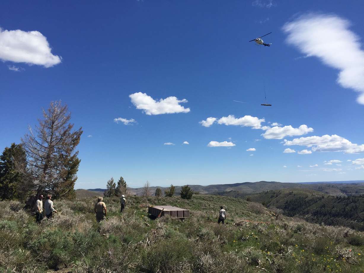 A helicopter drops off supplies for a "mega" water guzzler in the Book Cliffs range in eastern Utah on July 12, 2021. The 7,200-square-foot guzzler holds water collected from rain and snow for animals to drink.