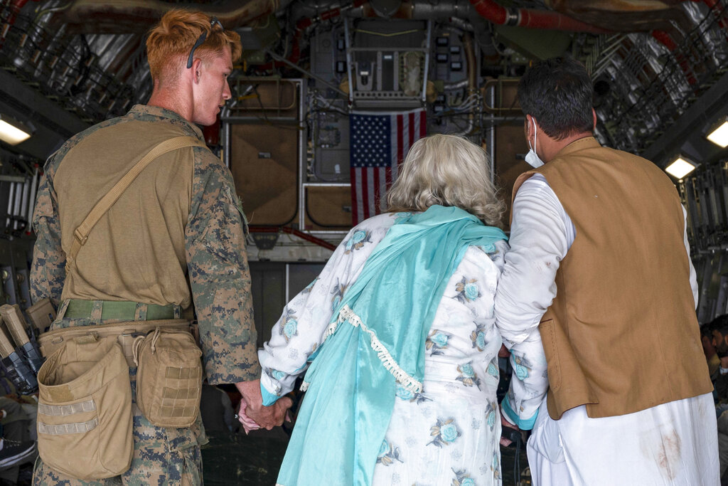 In this image provided by the U.S. Air Force, a U.S. Air Force aircrew assist evacuees aboard a U.S. Air Force C-17 Globemaster III aircraft at Hamid Karzai International Airport in Kabul, Afghanistan, Friday. Utah organizations say they will hold a prayer vigil for Afghan refugees in Murray Park Saturday.
