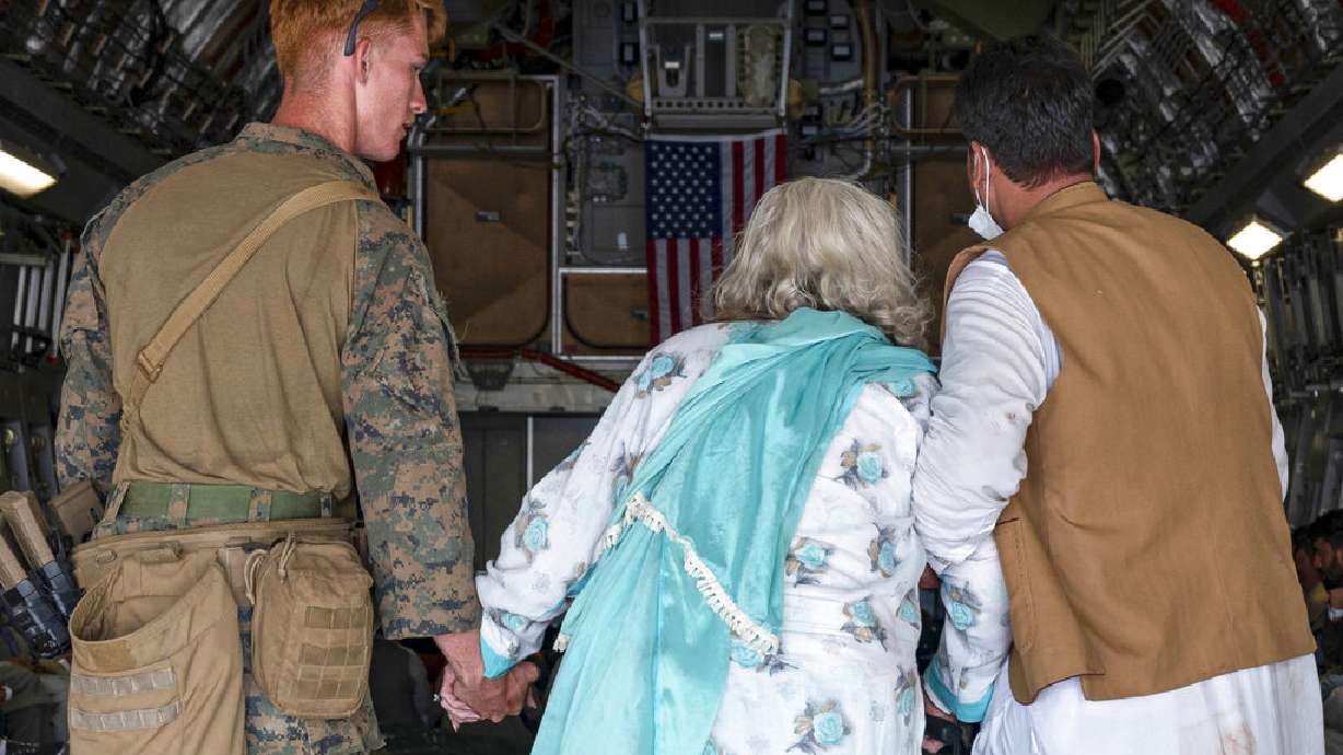 In this image provided by the U.S. Air Force, a U.S. Air Force aircrew assist evacuees aboard a U.S. Air Force C-17 Globemaster III aircraft at Hamid Karzai International Airport in Kabul, Afghanistan, Friday. Utah organizations say they will hold a prayer vigil for Afghan refugees in Murray Park Saturday.