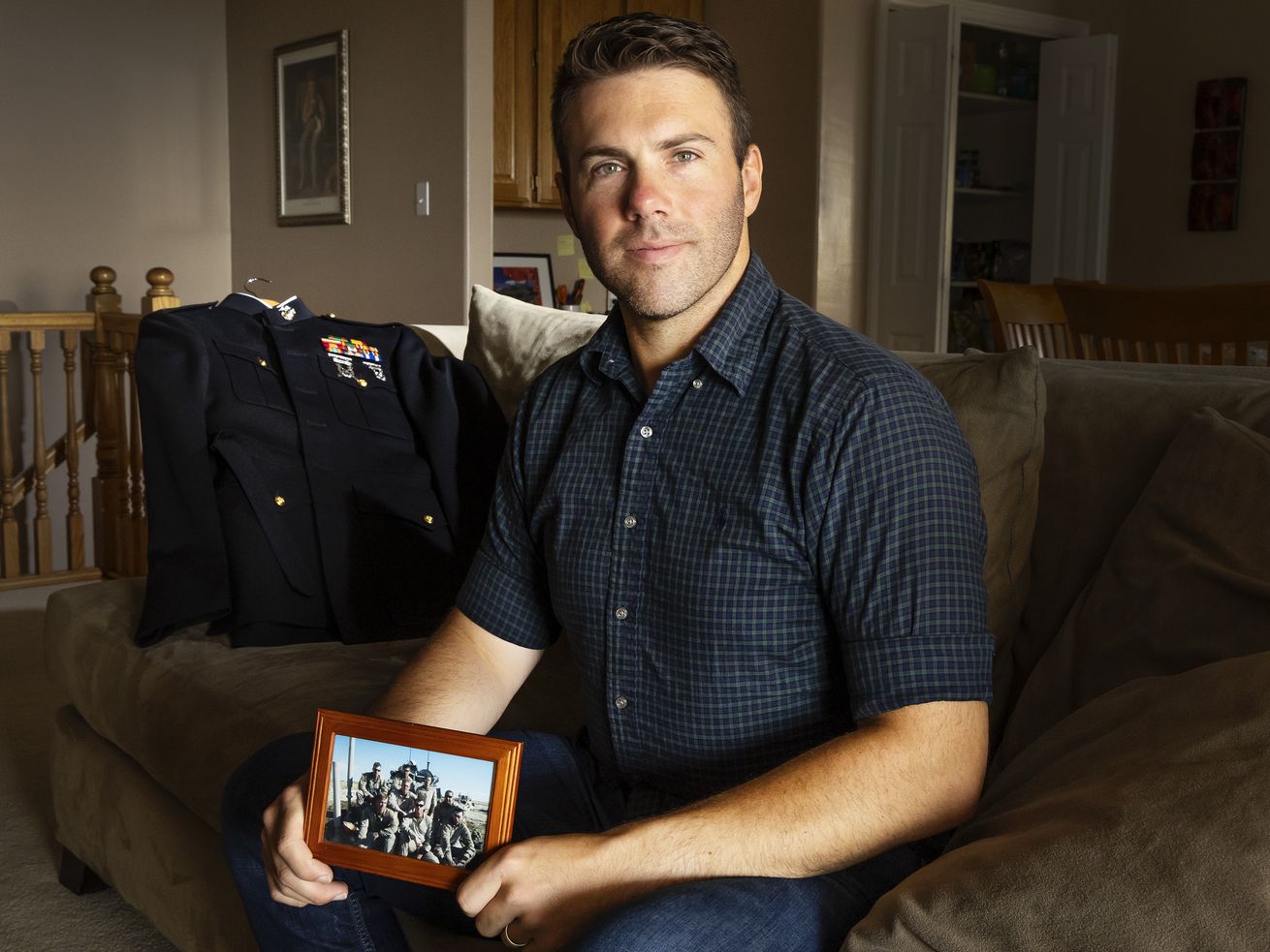Jeremy Ruppe, a Marine who served with the 4th Light Armored Reconnaissance Battalion in Afghanistan, holds a photo of
his crew in Afghanistan while posing for photos at his home in Lindon on Friday.